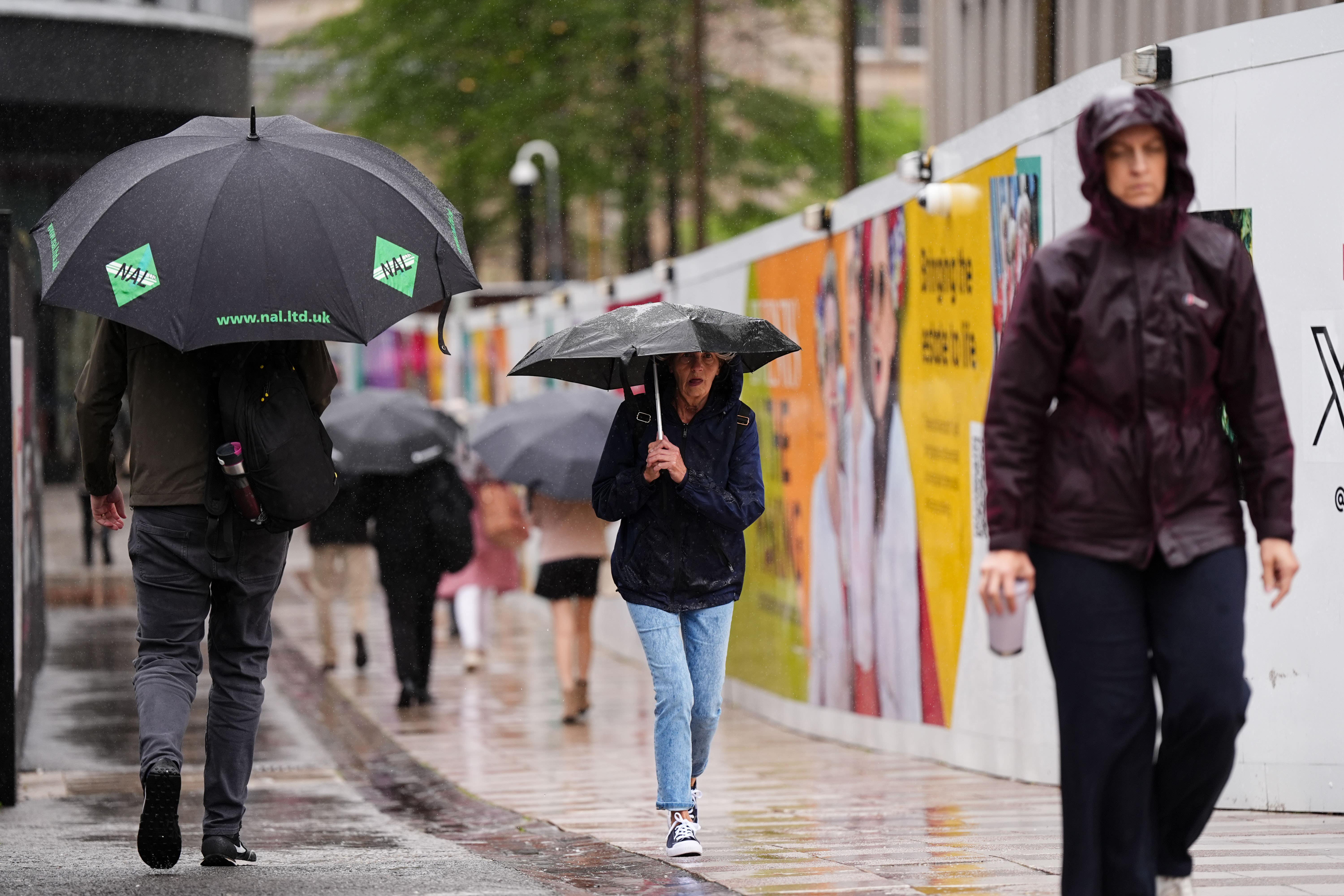 People shield themselves from the rain during Storm Floris
