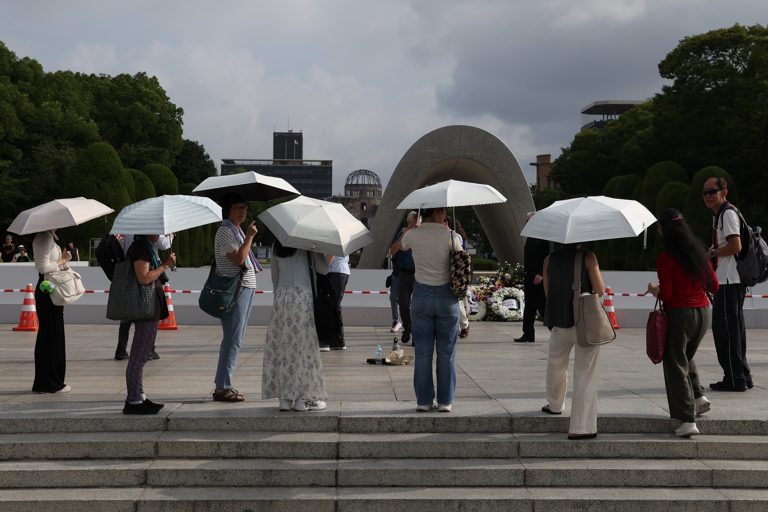 Visitors use umbrellas to shelter from the sun at the Hiroshima Peace Memorial