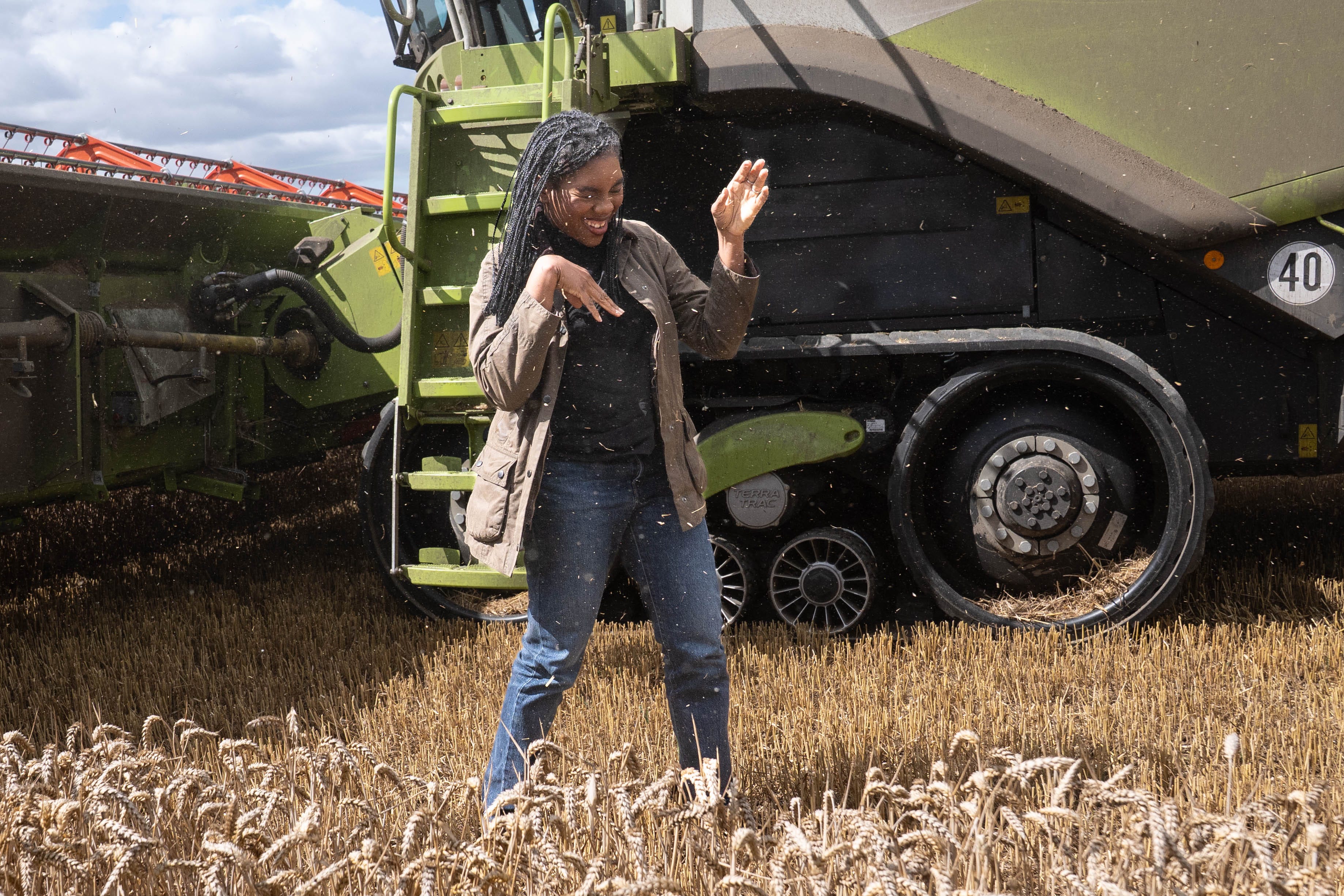 Conservative Party leader Kemi Badenoch wipes away grain dust after she tried her hand at harvesting wheat (Stefan Rousseau/PA)