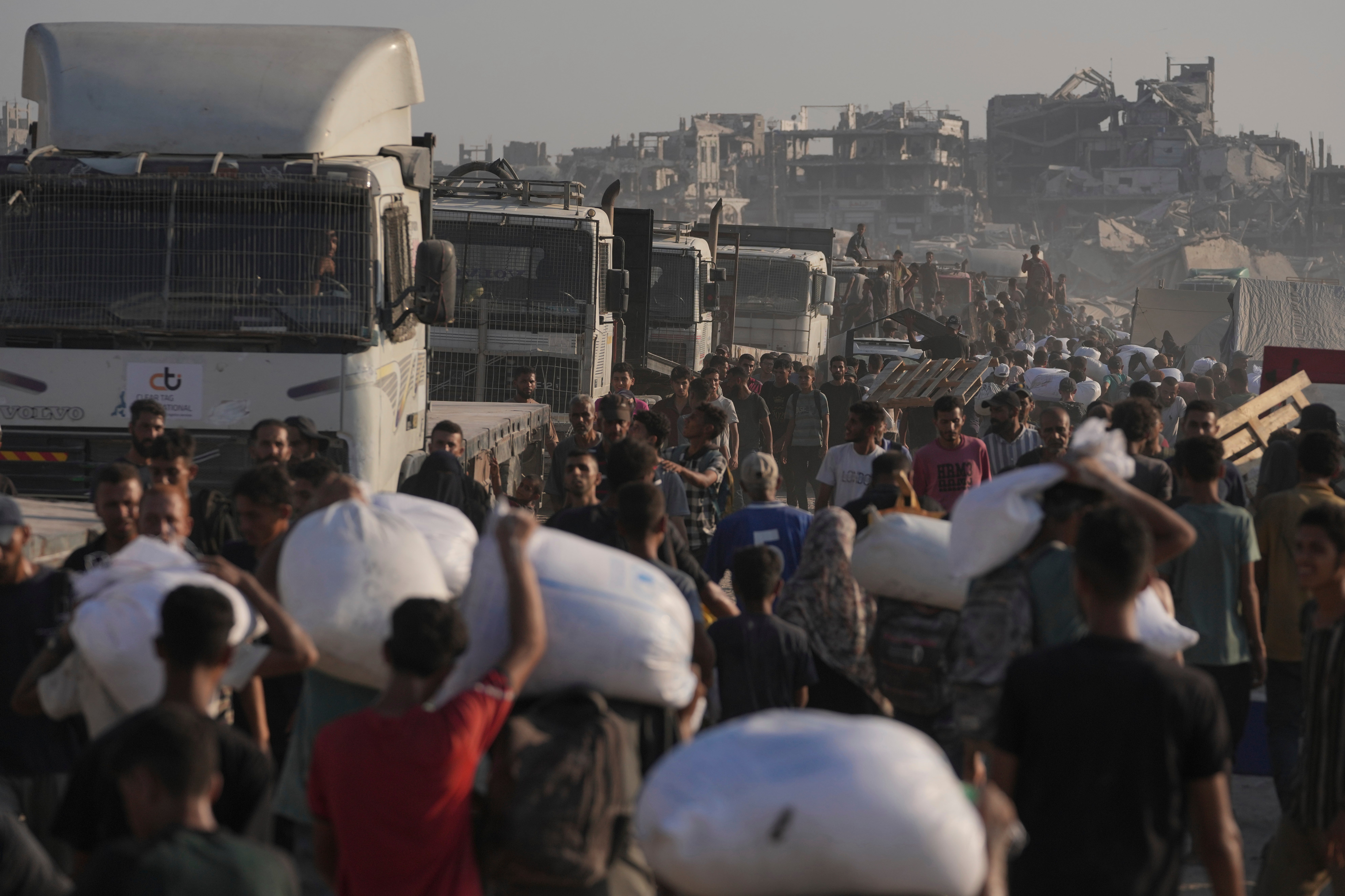 Palestinians carry sacks of flour unloaded from a humanitarian aid convoy that reached Gaza City