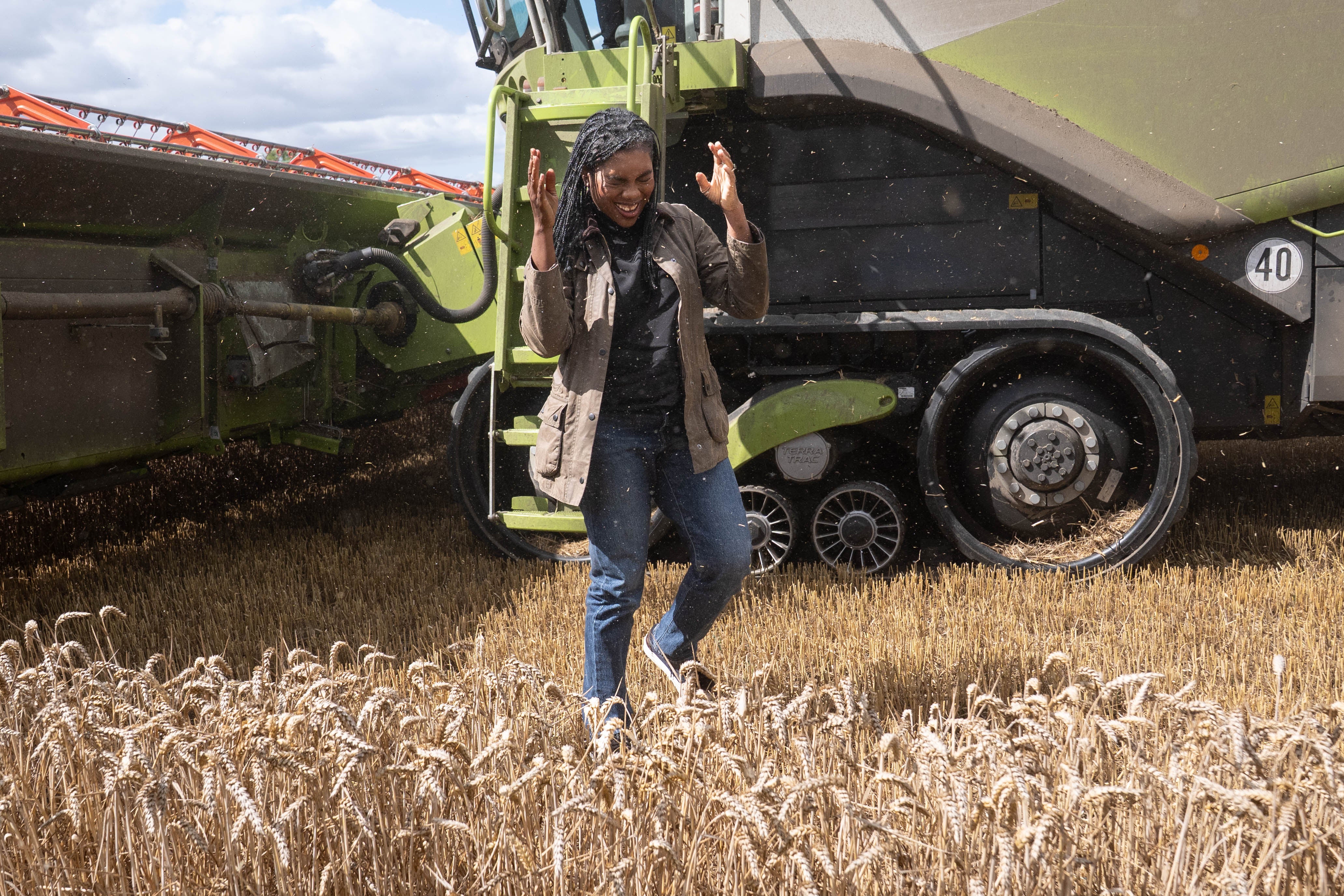 Conservative Party leader Kemi Badenoch wipes away grain dust after trying her hand at harvesting wheat (Stefan Rousseau/PA)