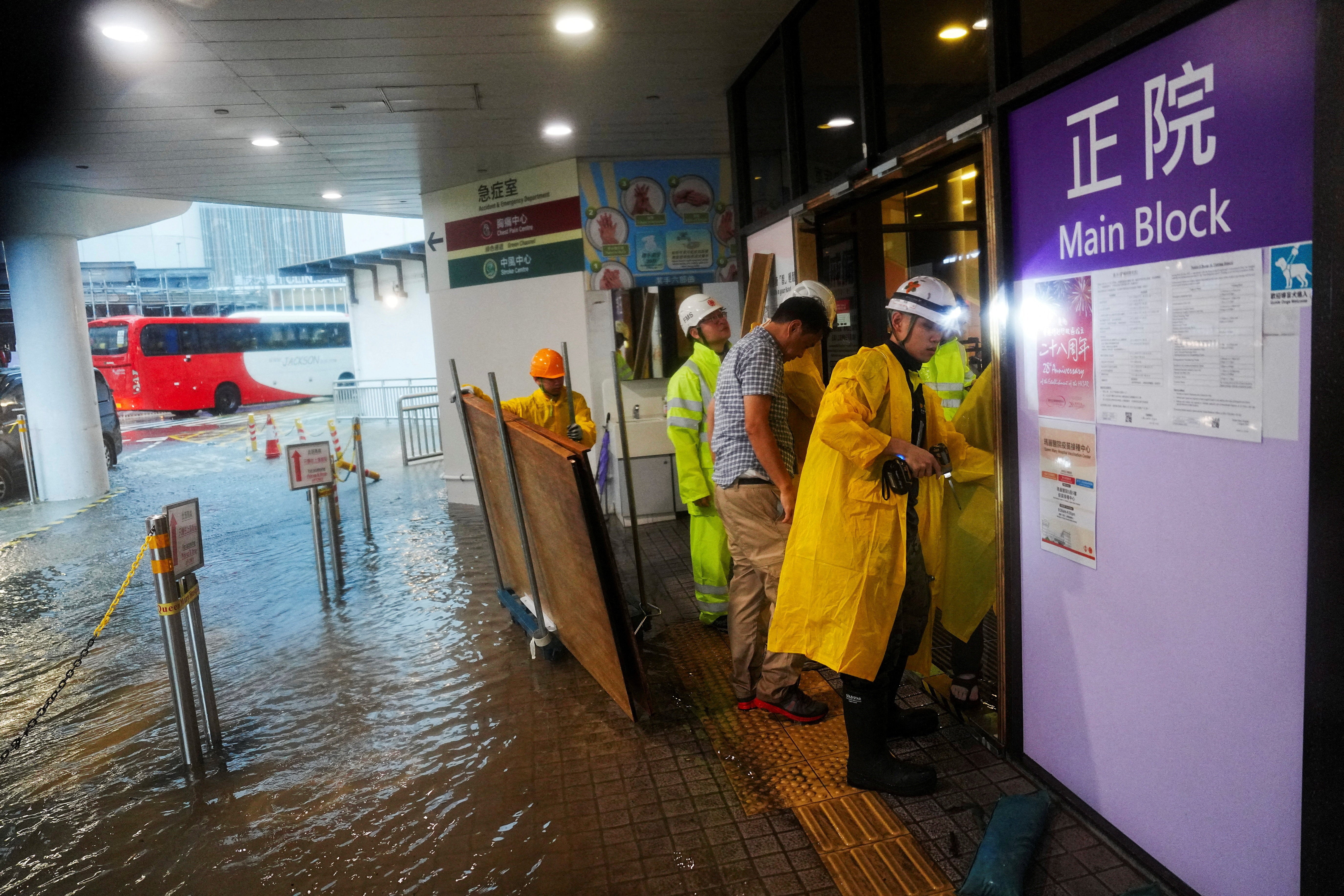 Workers place a blockade outside a flooded hospital during heavy rains in Hong Kong on 5 August 2025