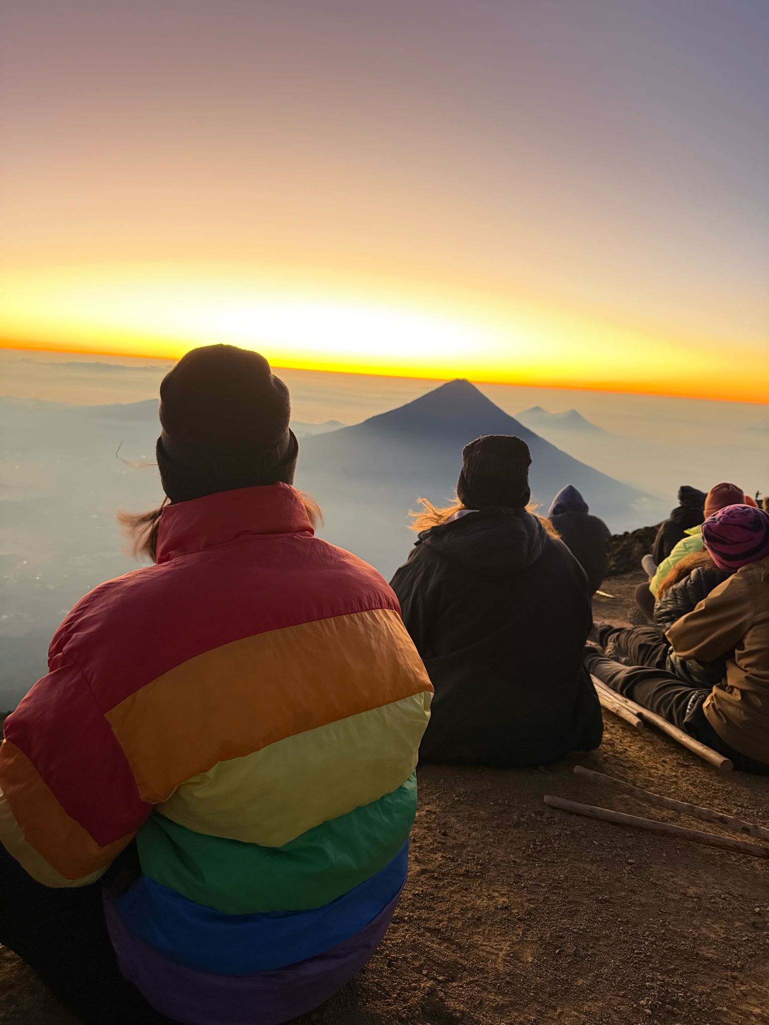 Hikers watch the sunrise over Fuego