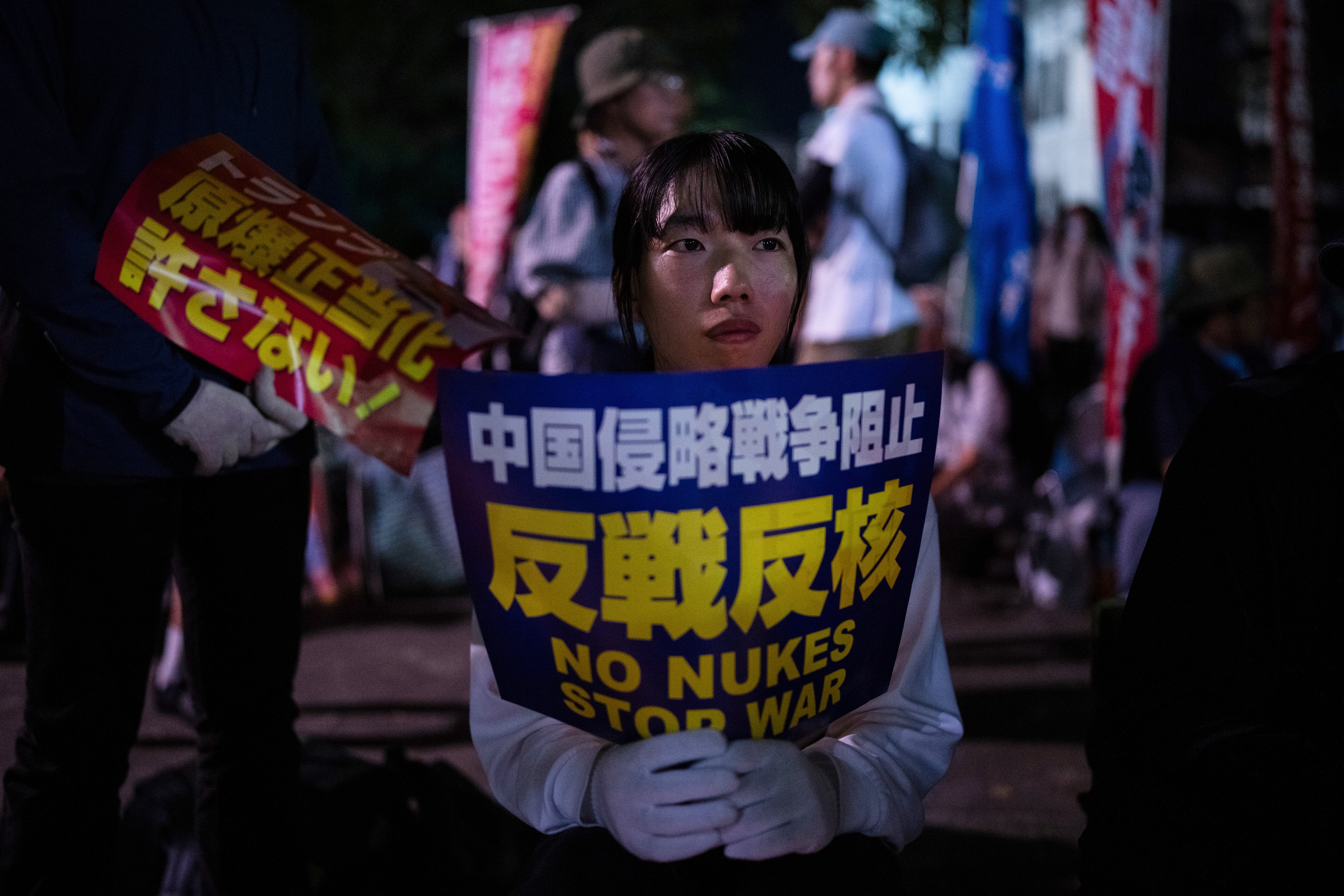 Protesters sit outside the Atomic Bomb Dome ahead of the memorial service to mark the 80th anniversary of the bombing in Hiroshima