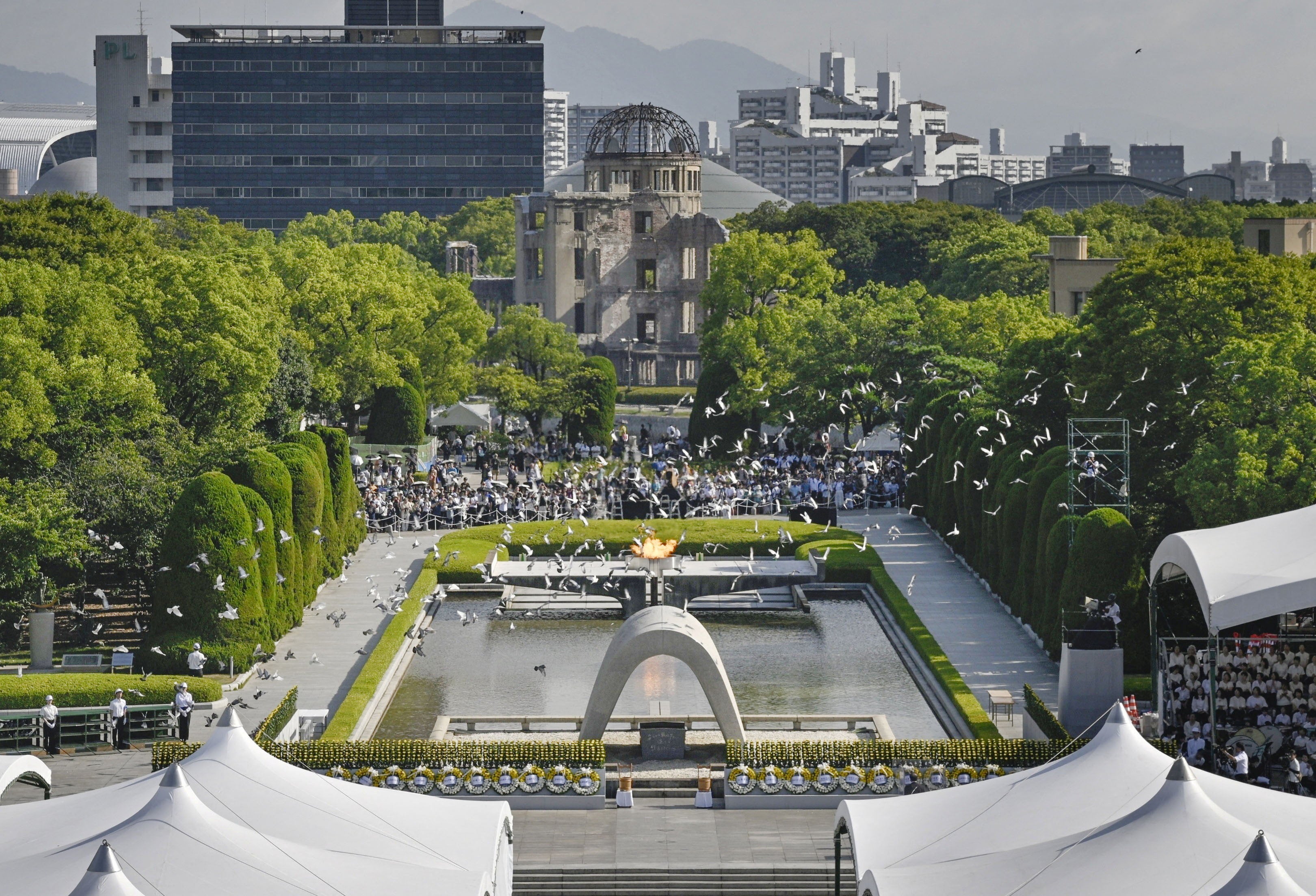 Doves fly over the Peace Memorial Park with a view of the gutted Atomic Bomb Dome at a ceremony in Hiroshima, western Japan, in this photo taken by Kyodo