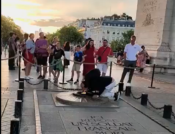 The man was seen crouching down behind the fence to reach the flame