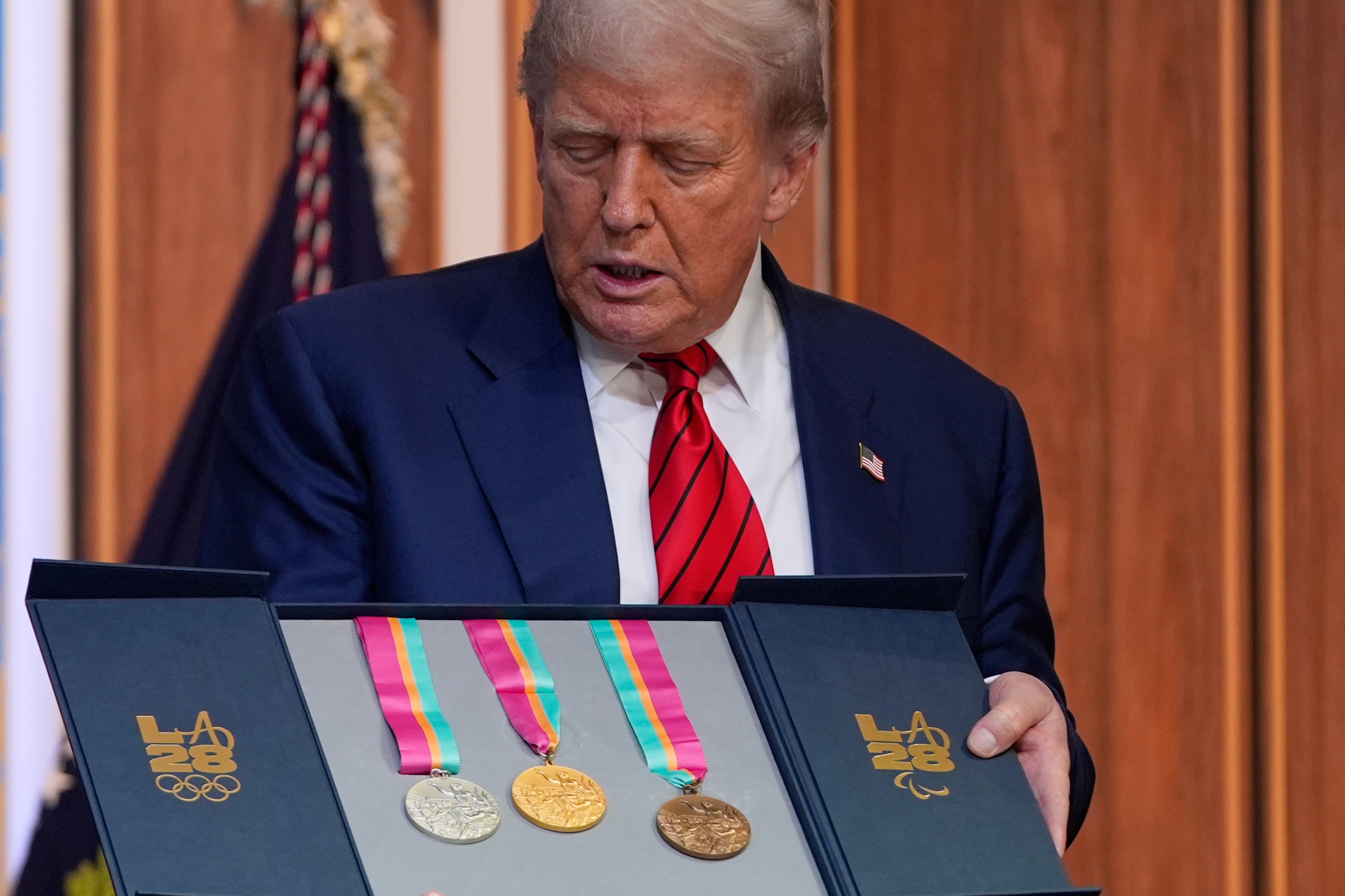 Trump poses with a set of vintage Olympic medals during an event announcing the White House task force for the 2028 Summer Olympics