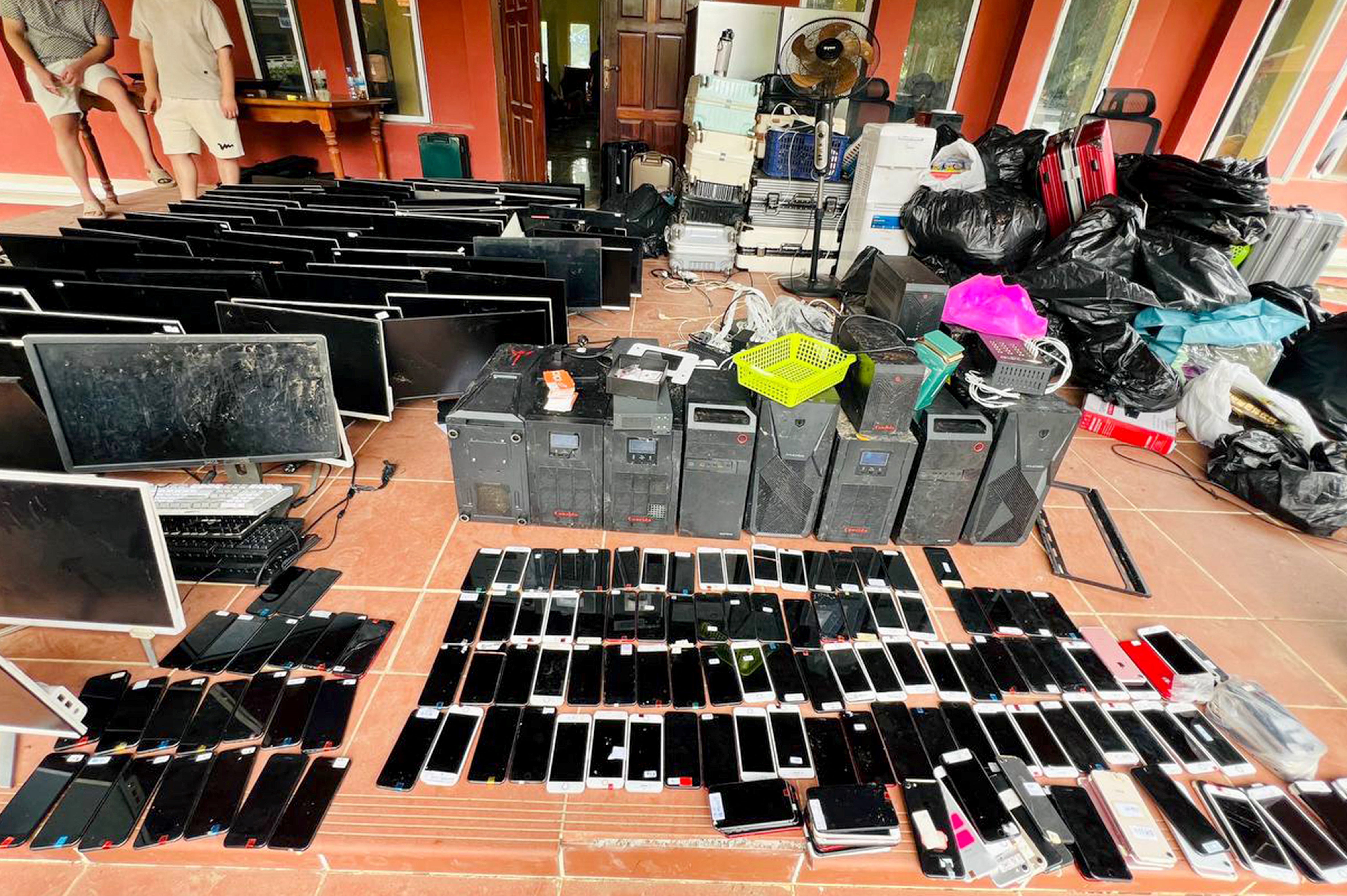Computers, smartphones and other equipment seized during a raid on a scam centre in Cambodia's Kandal province