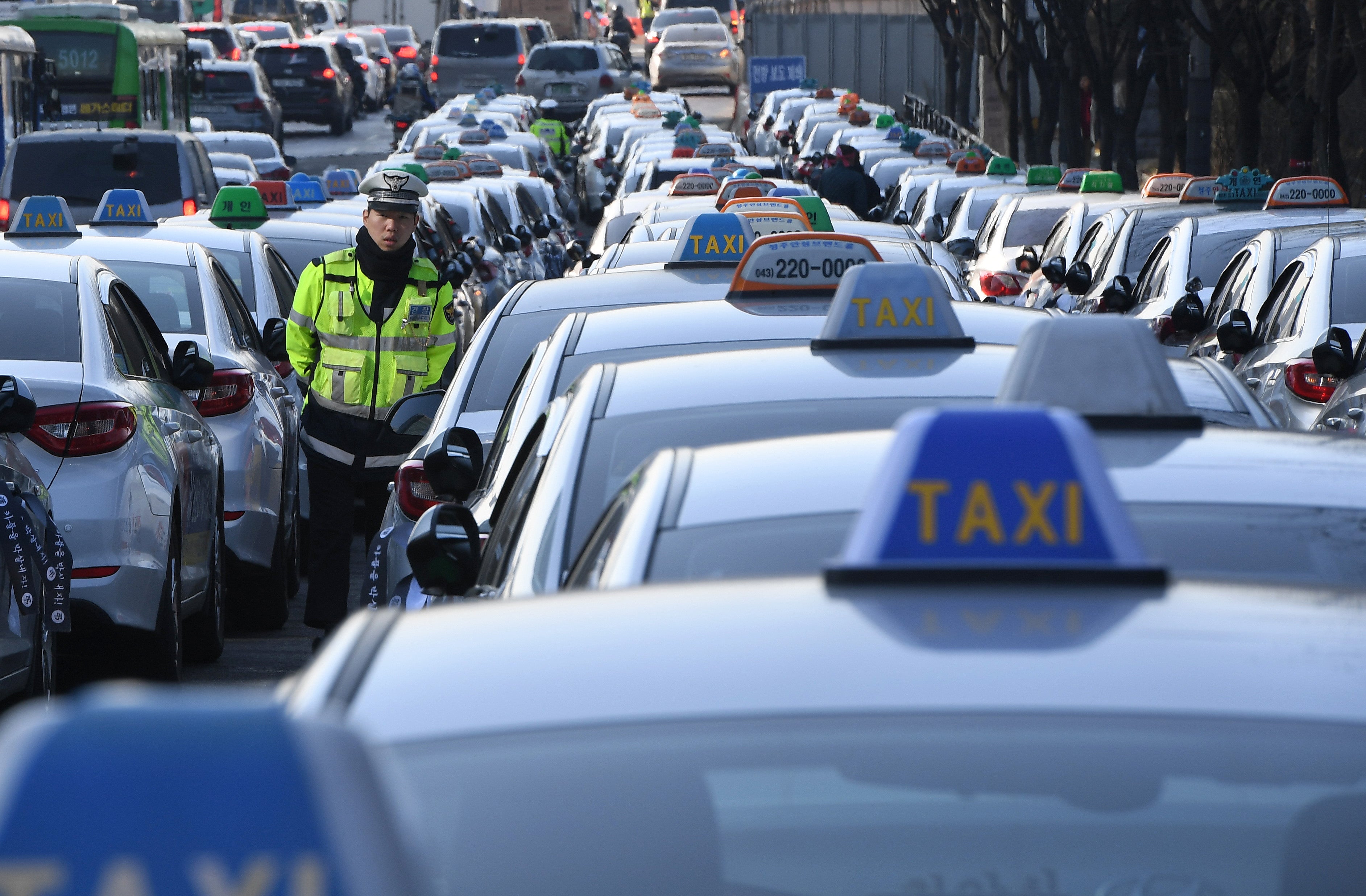 <p>File. Policeman walks among South Korean taxis in 2018</p>