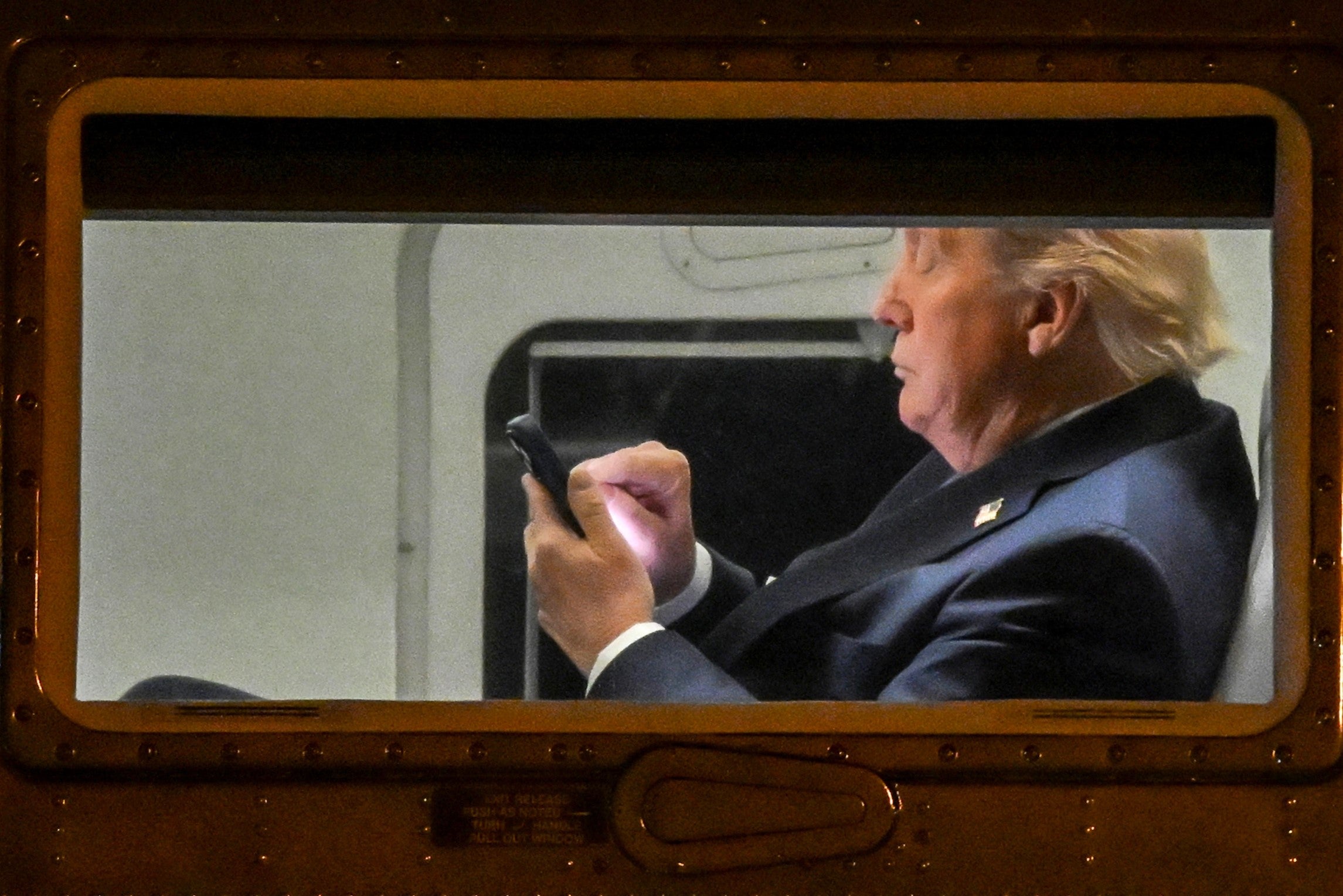 US President Donald Trump uses a phone aboard Marine One before it departs Leesburg Executive Airport in Leesburg, Virginia, on 24 April, 2025