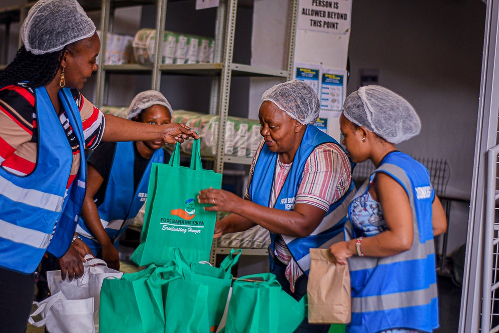 A woman receives a food package from Food Banking Kenya, which has reported soaring demand in the wake of cuts to USAID