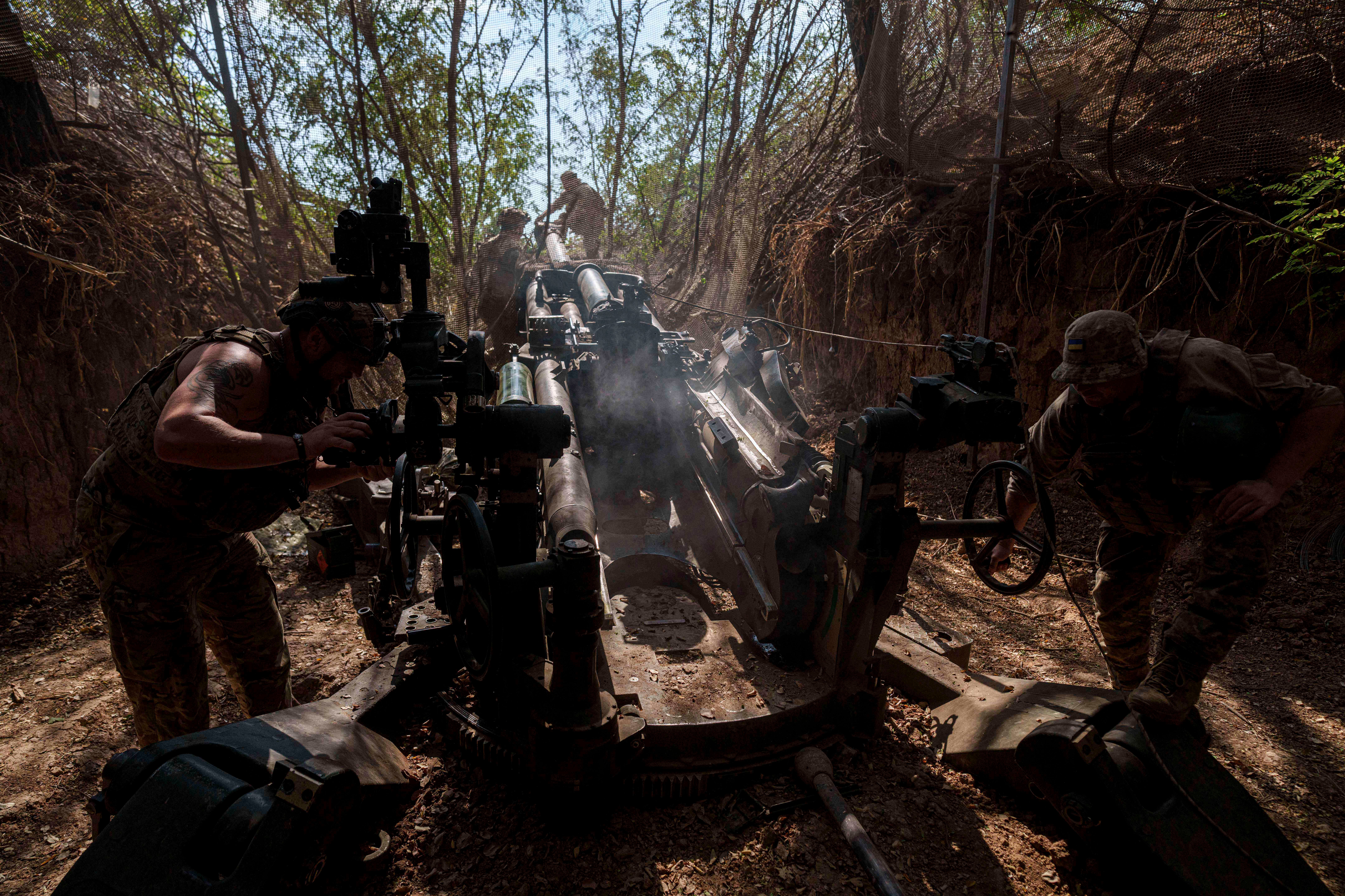 Ukrainian servicemen of the 148th artillery brigade set up a M777 howitzer before firing towards Russian positions at the frontline in Zaporizhzhia region
