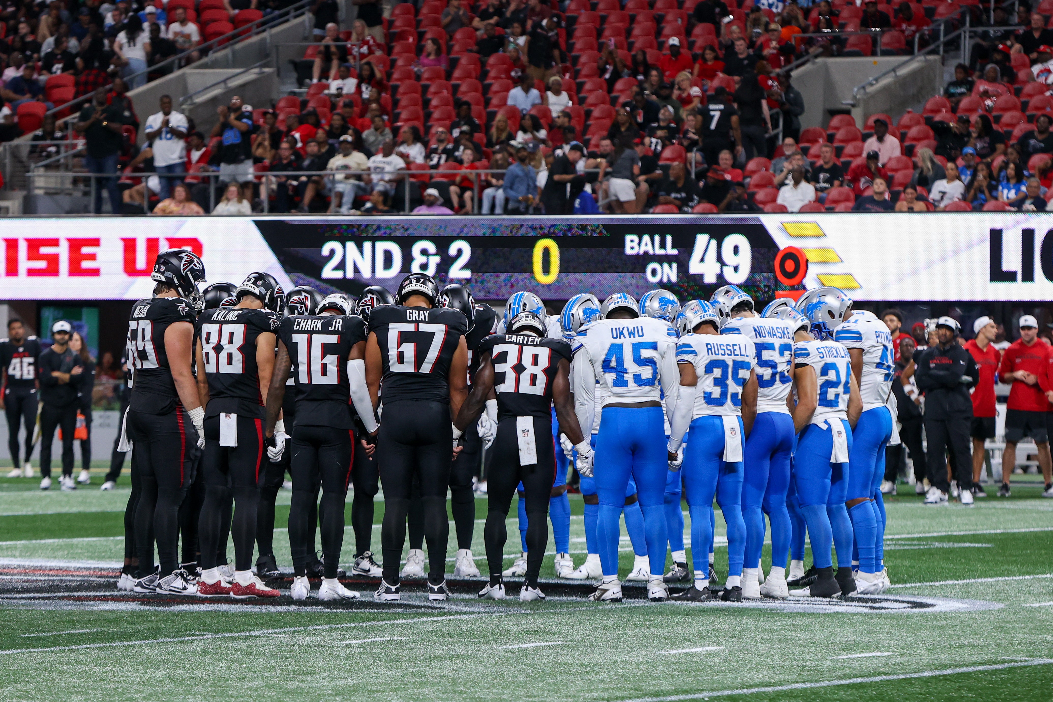 Atlanta Falcons a Detroit Lions hráči se modlí po zranění