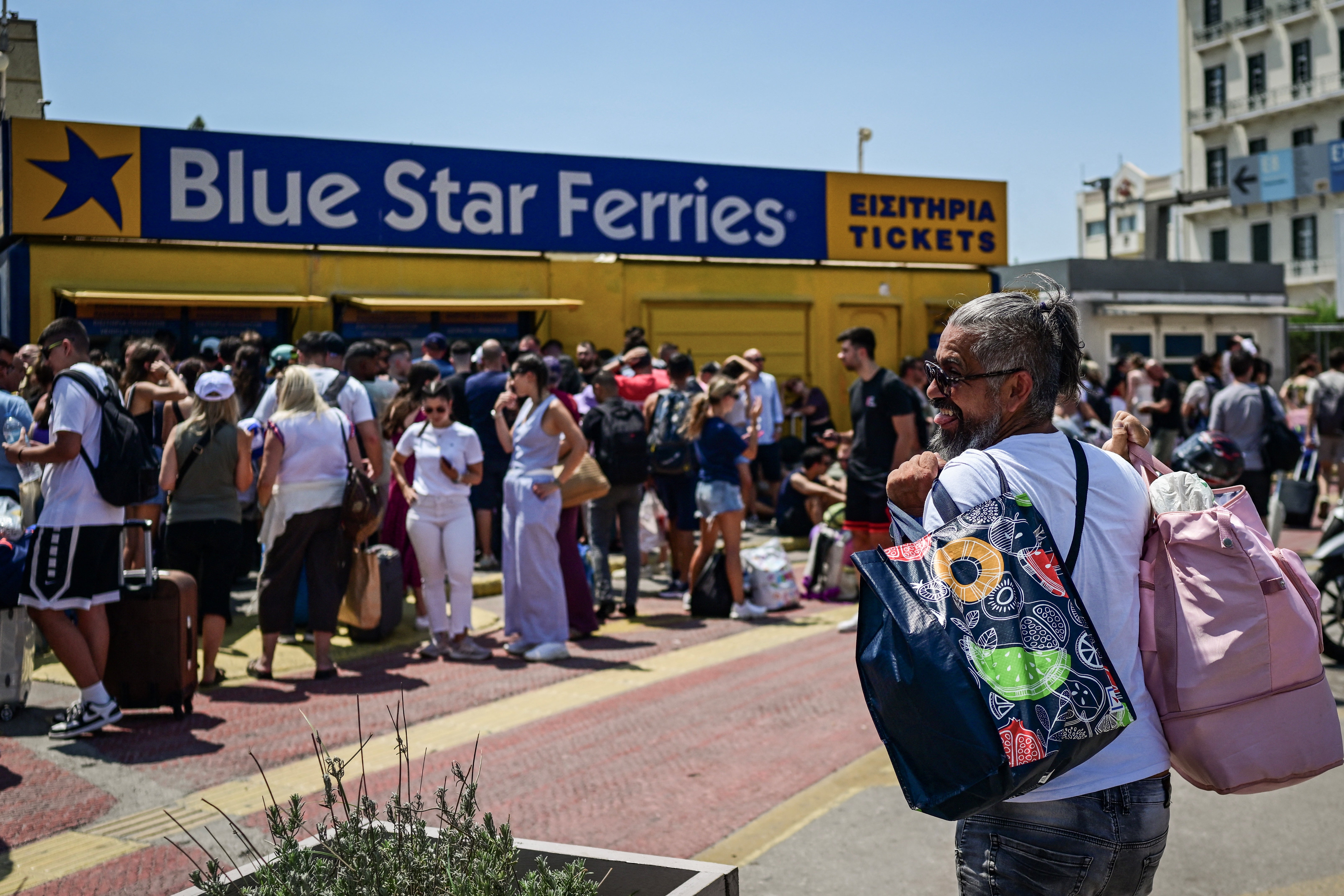 People stand outside ticket offices at the port of Piraeus, near Athens; Ferry services between Athens and the Cyclades were heavily disrupted by the gale-force winds, leaving travellers stranded