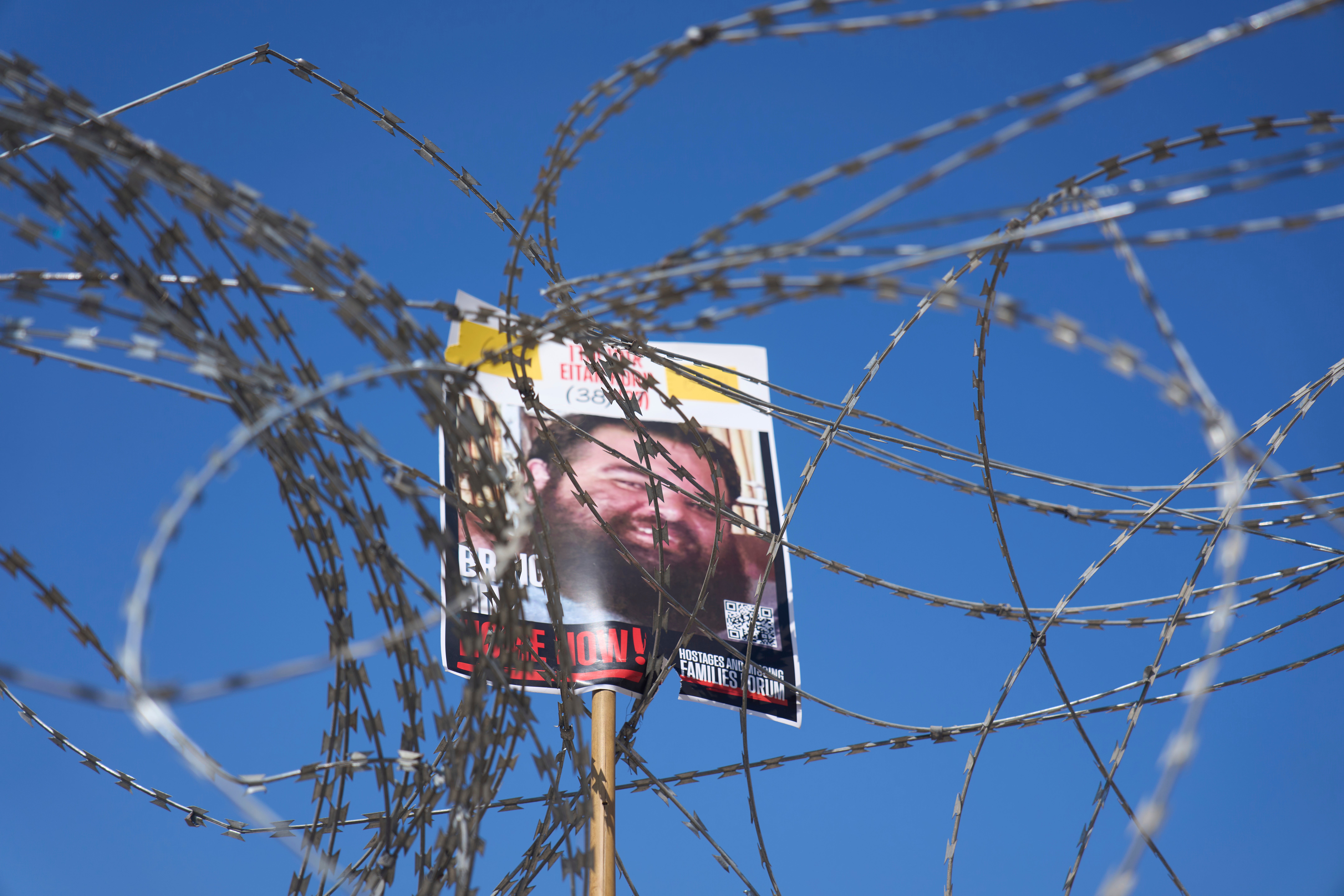 A picture of hostage Eitan Horn, held in Hamas captive in the Gaza Strip, hangs on a barbed wire during a protest by families at the plaza known as the hostages square in Tel Aviv, Israel, Saturday, Aug. 2