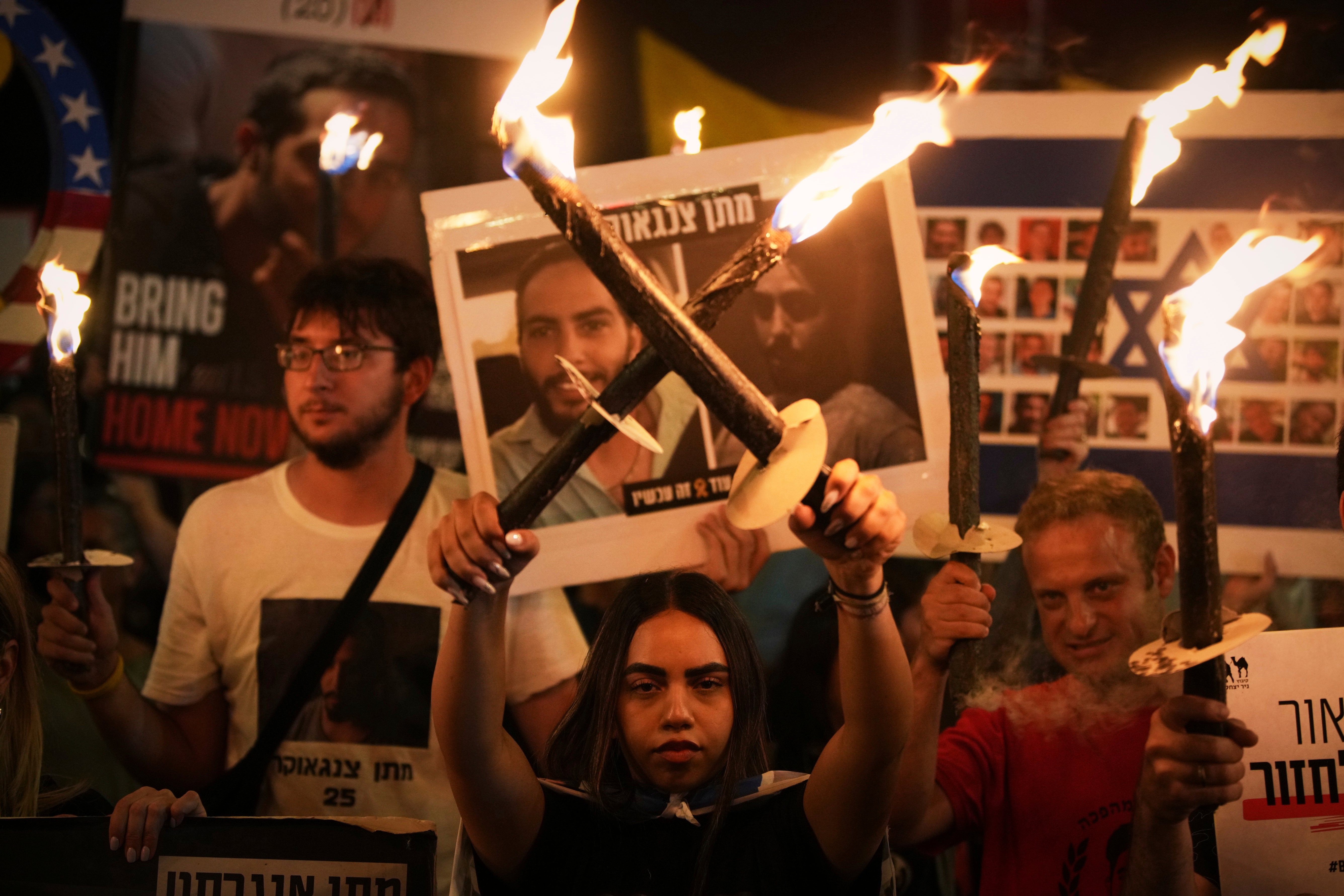 Demonstrators light torches during a protest demanding the release of all hostages from Hamas captivity in the Gaza Strip and calling for an end to the war, outside the prime minister’s office in Jerusalem