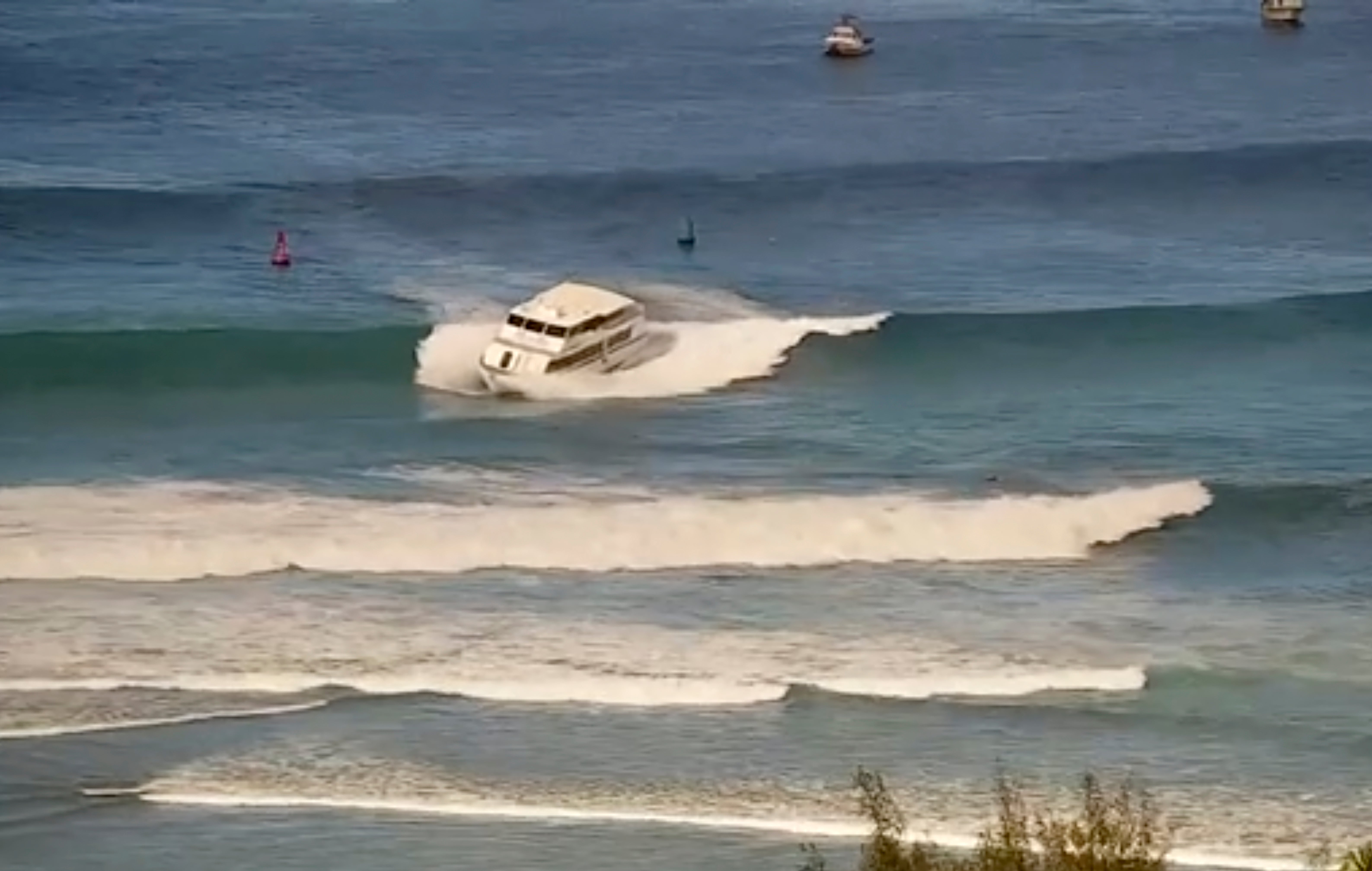 Esta imagen fija de un video proporcionado por la Guardia Costera de EE. UU. Muestra un barco de pasajeros de 75 pies que se ejecuta cerca del puerto de la cuenca de Kewaro en Honolulu el sábado 9 de agosto de 2025.