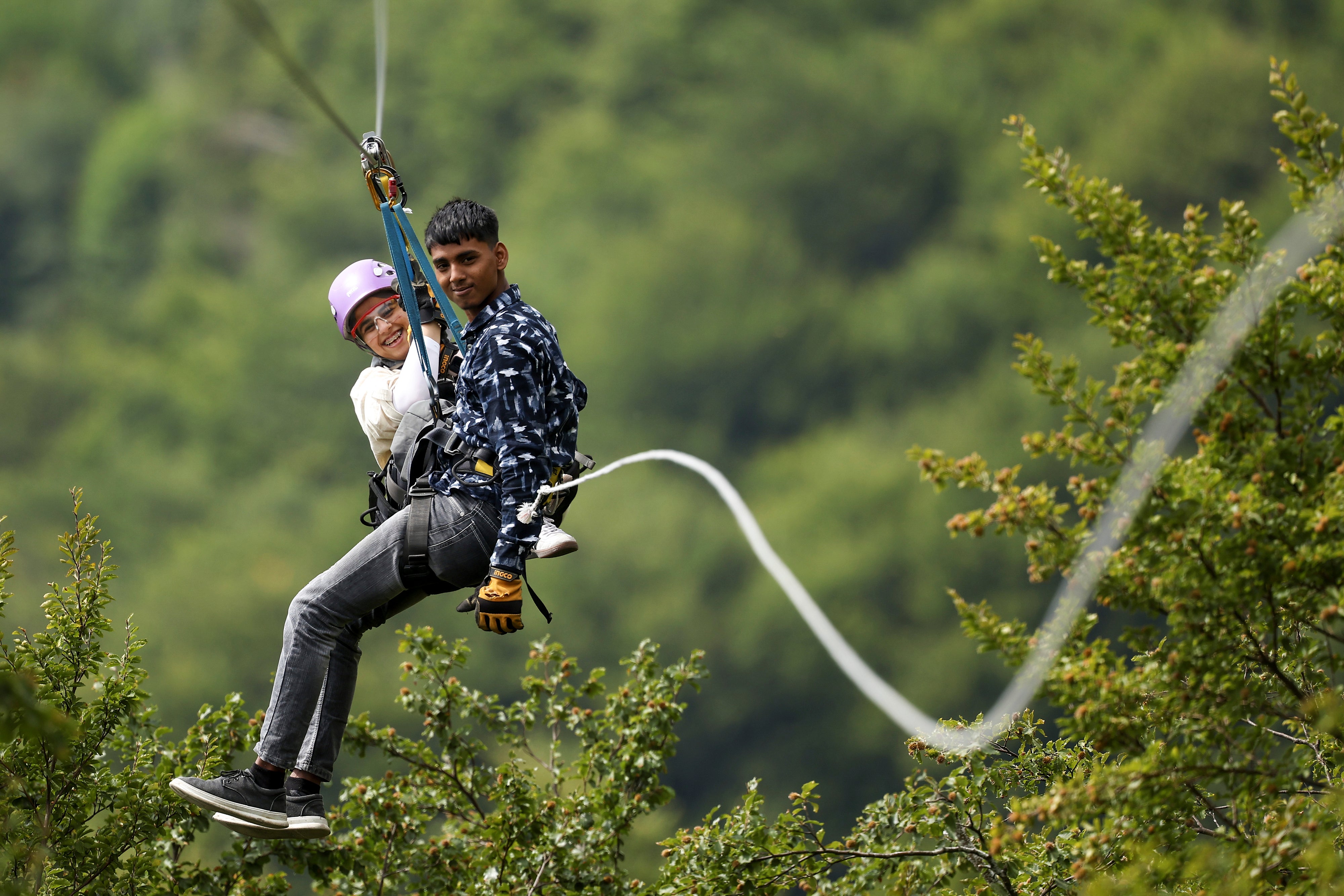 Tourists ride on a zip line on Bjelasnica mountain near Sarajevo, Bosnia, Tuesday, Aug. 5, 2025. (AP Photo/Armin Durgut)