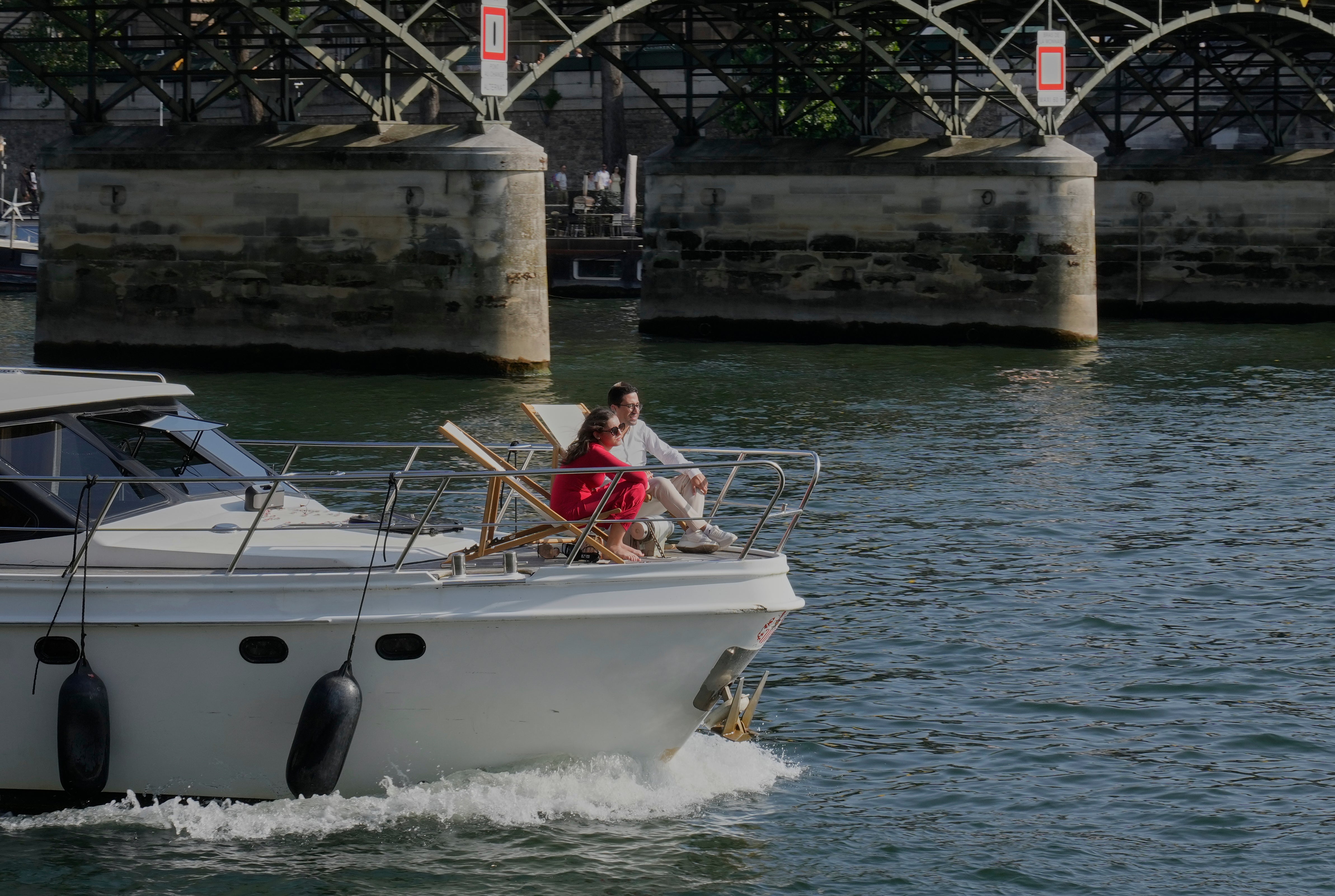 People enjoy the sun on a boat on the Seine river in Paris, Sunday, Aug. 10, 2025. (AP Photo/Michel Euler)