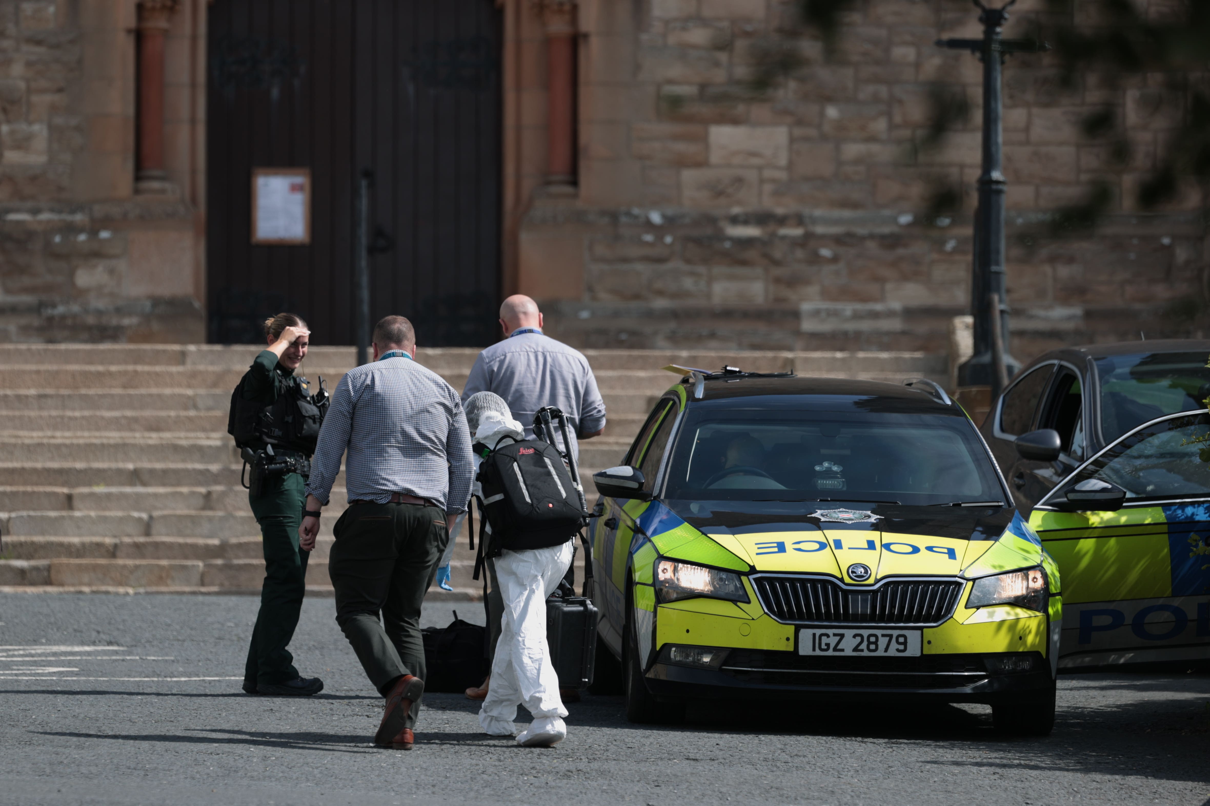 Police Service of Northern Ireland officers and a scenes of crime officer outside St Patrick’s Church in Downpatrick