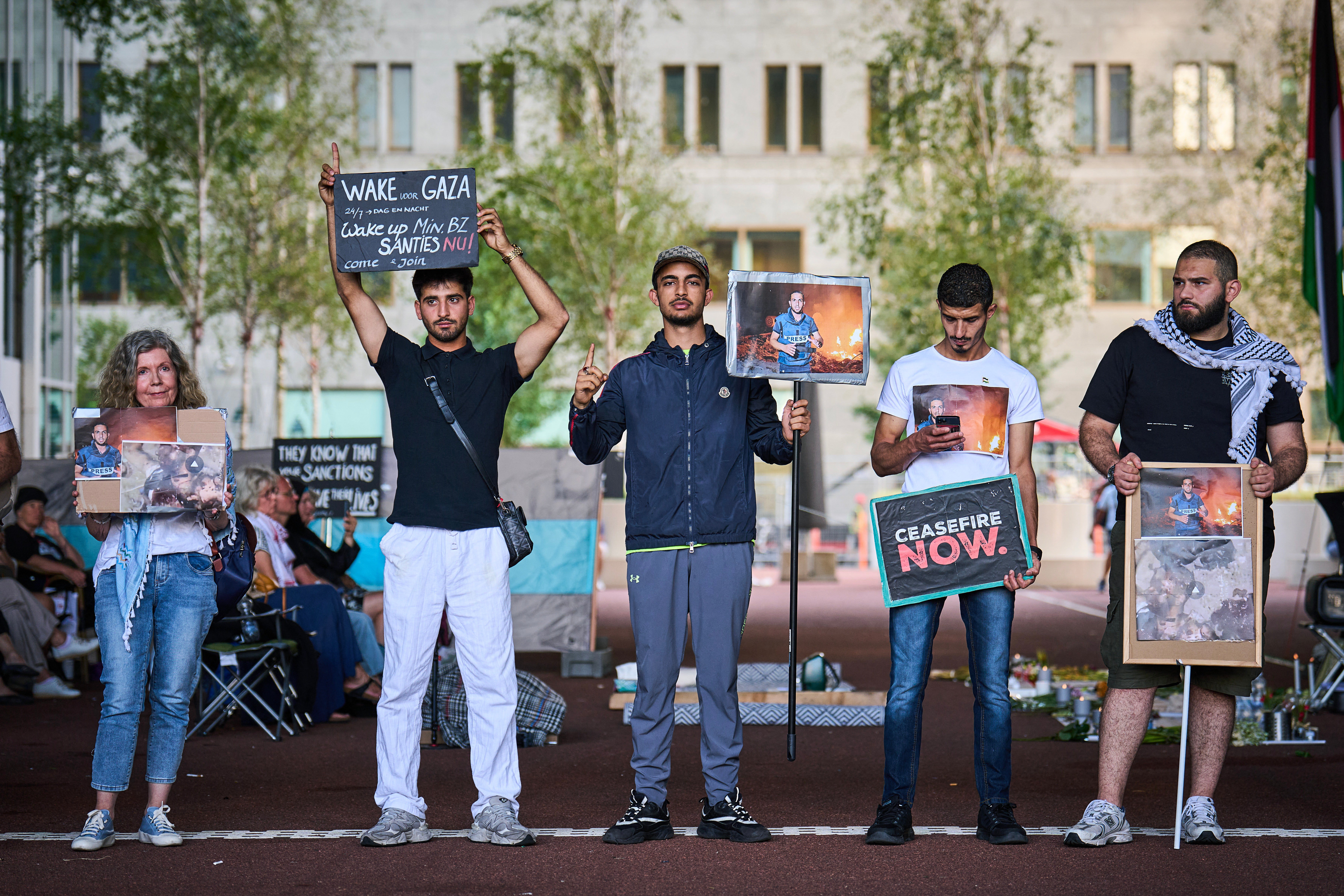 Demonstrators hold placards depicting portraits of the late Palestinian journalist Anas al-Sharif as they gather for a vigil to commemorate all journalists killed in Gaza, at the Ministry of Foreign Affairs in The Hague, on 11 August