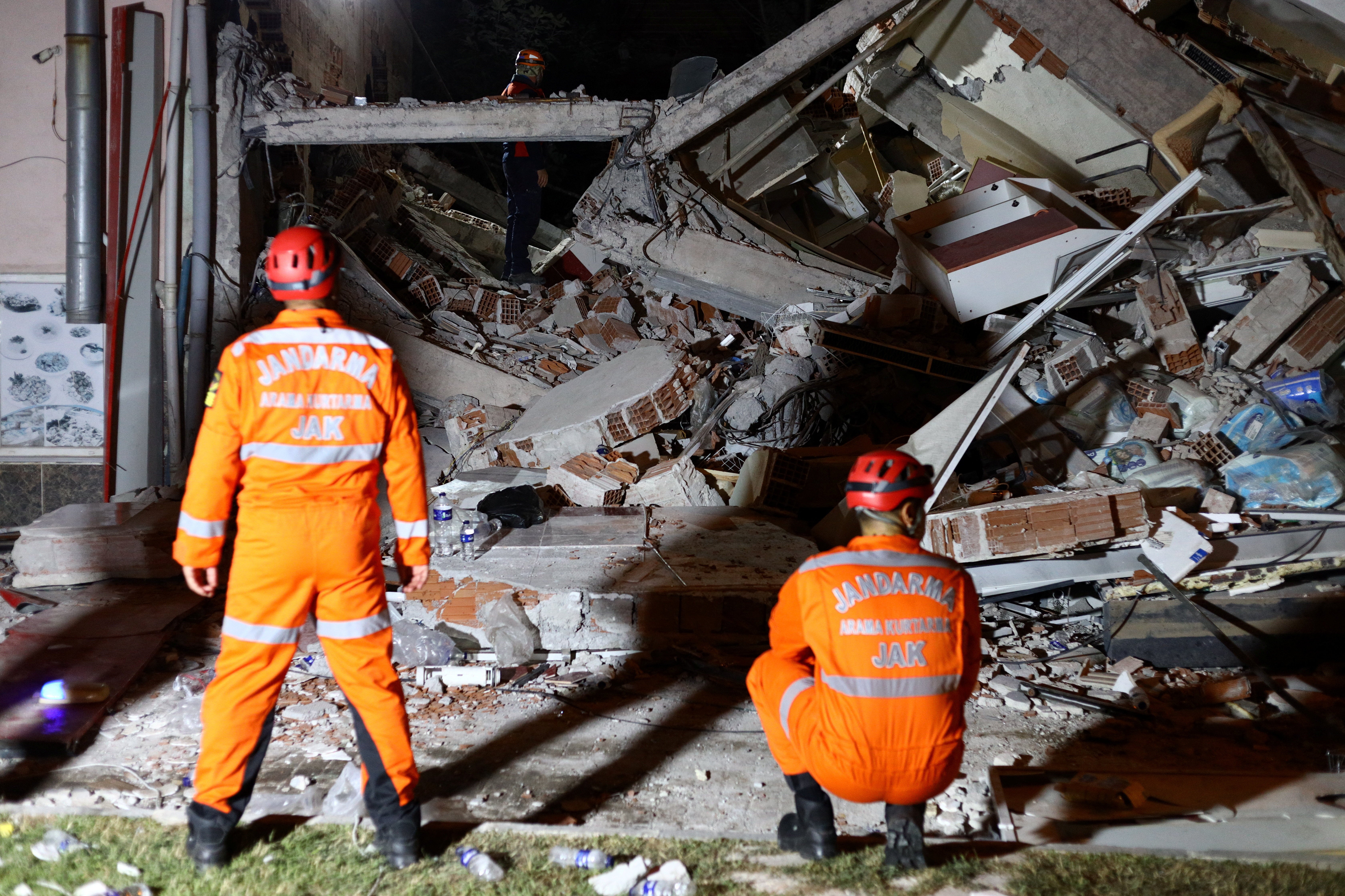 Turkish search and rescue personnel work at the site of a collapsed building in Sindirgi