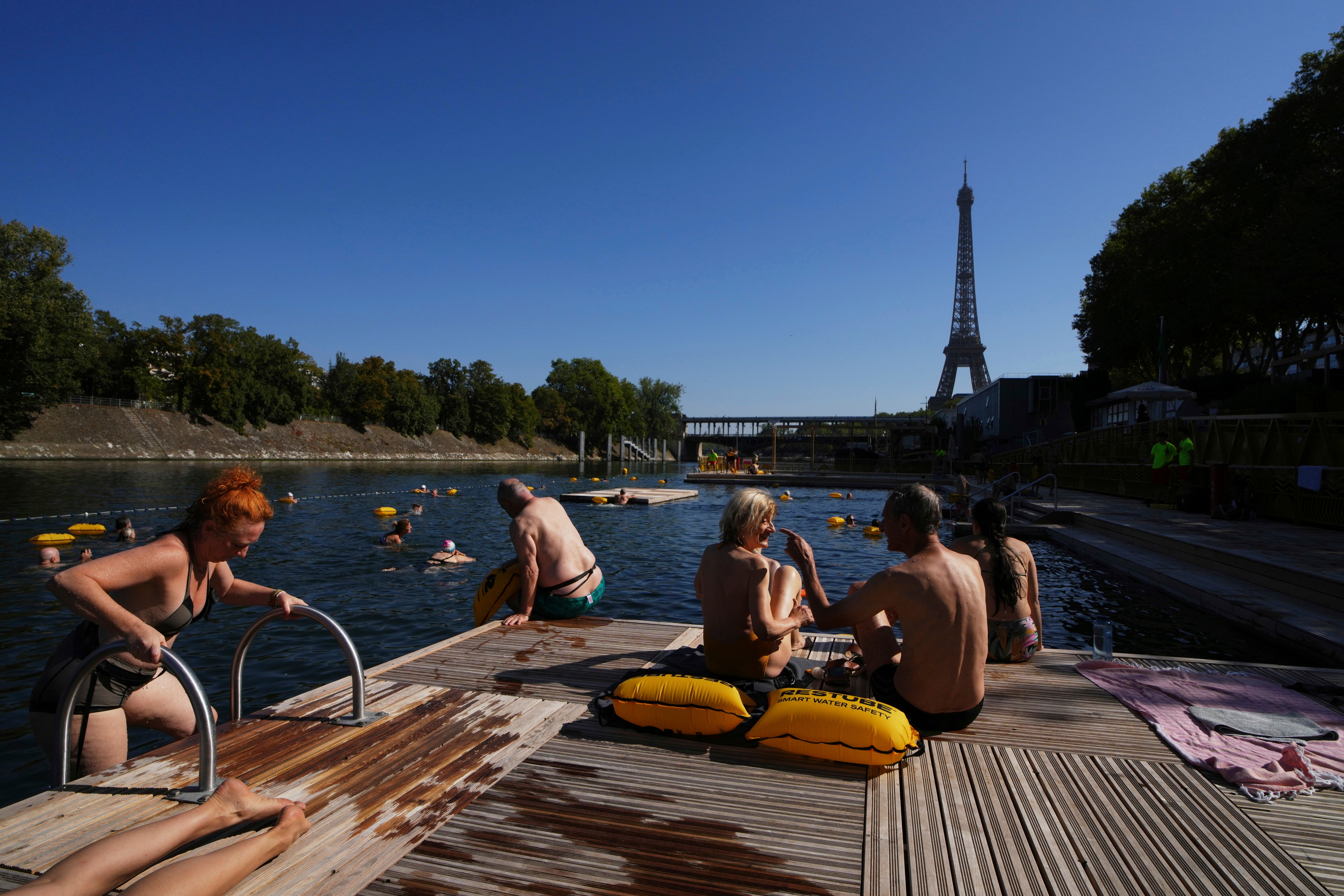 People enjoy the sun after a dip in the Seine