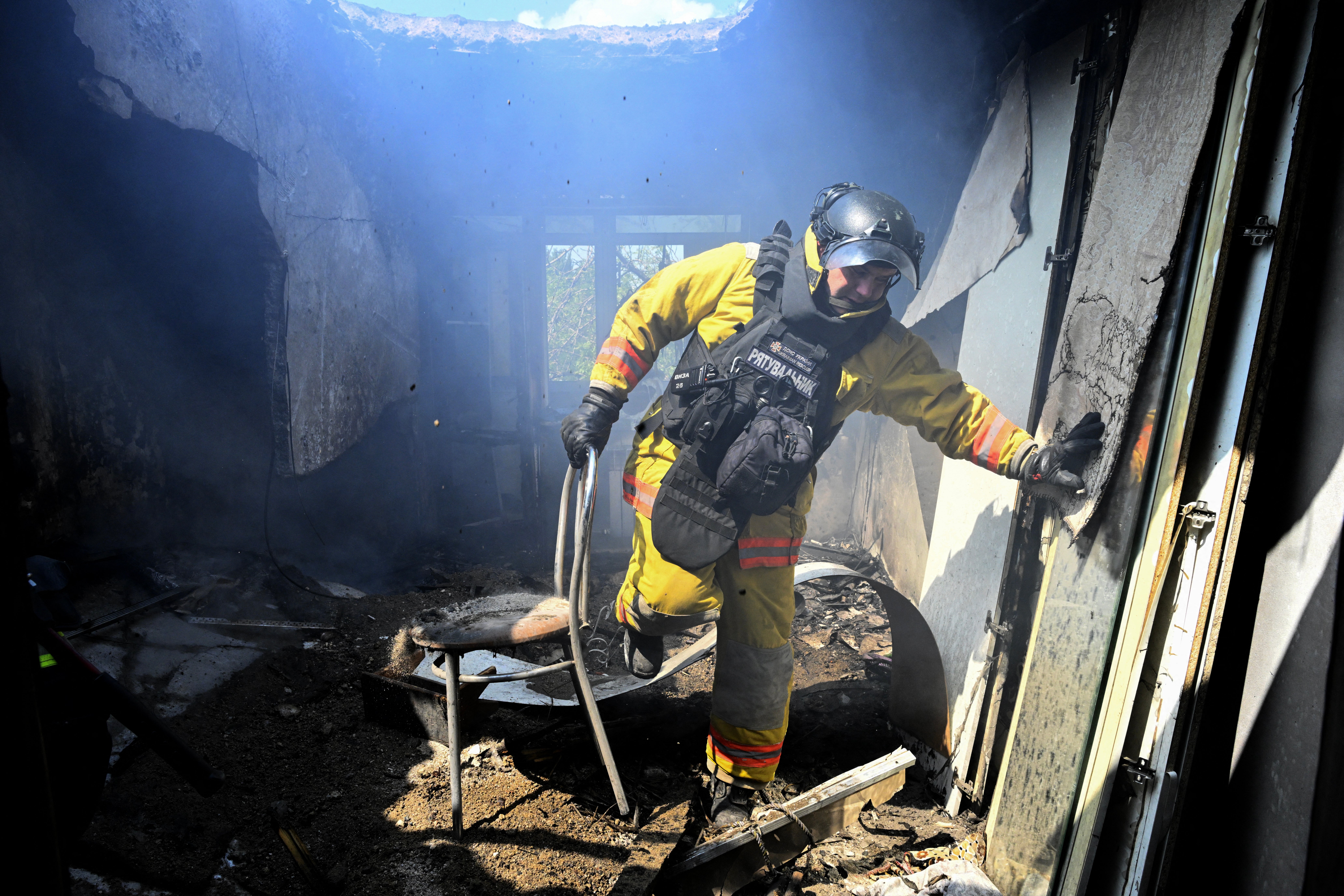 An Ukrainian firefighter extinguishes a fire in a destroyed apartment following a Russian drone strike in the town of Bilozerske, Donetsk region on 10 August 2025, amid the Russian invasion of Ukraine