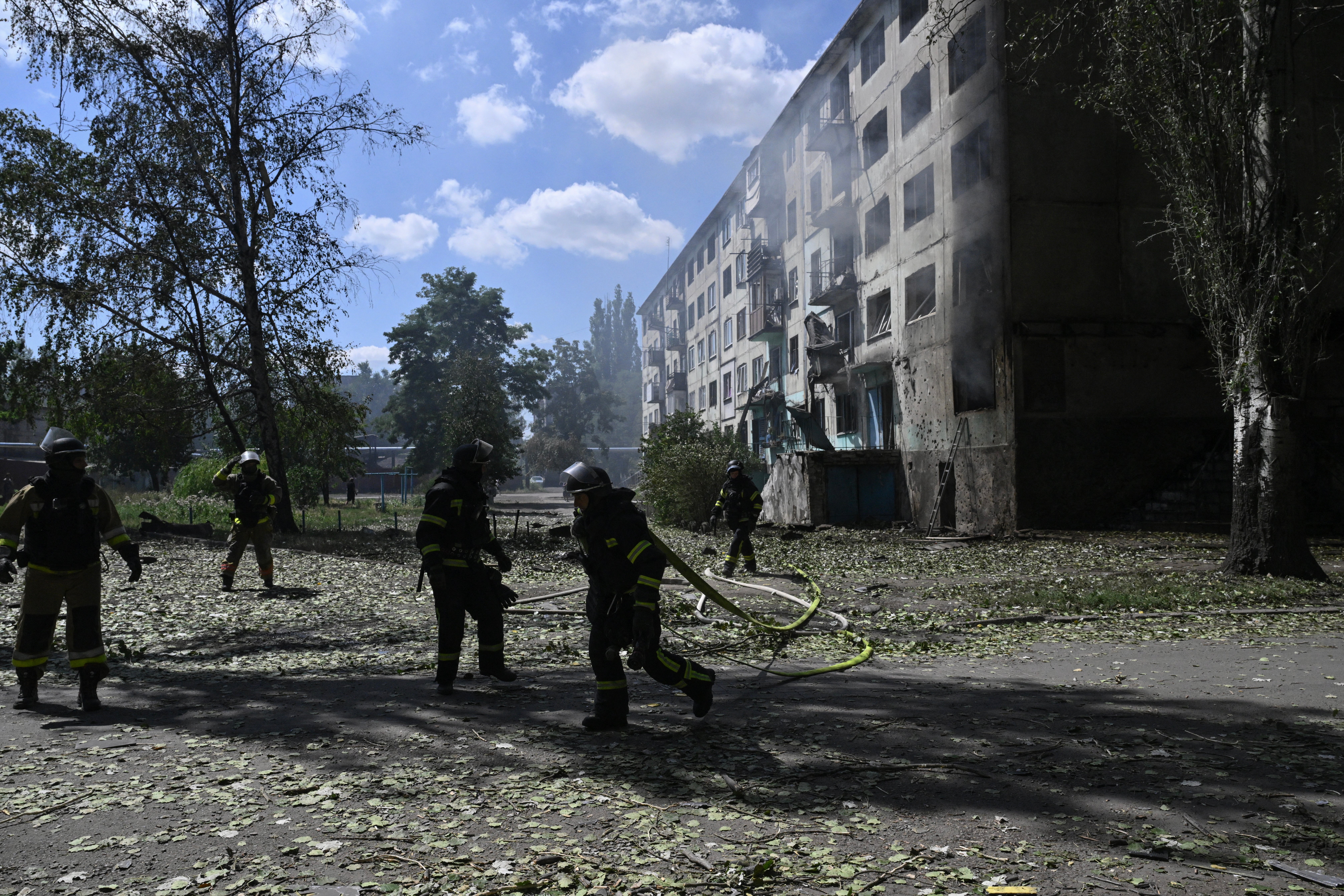 Ukrainian firefigters extinguish fire in a residential building at the site of a Russian drone strike in the town of Bilozerske, Donetsk region on 10 August 2025