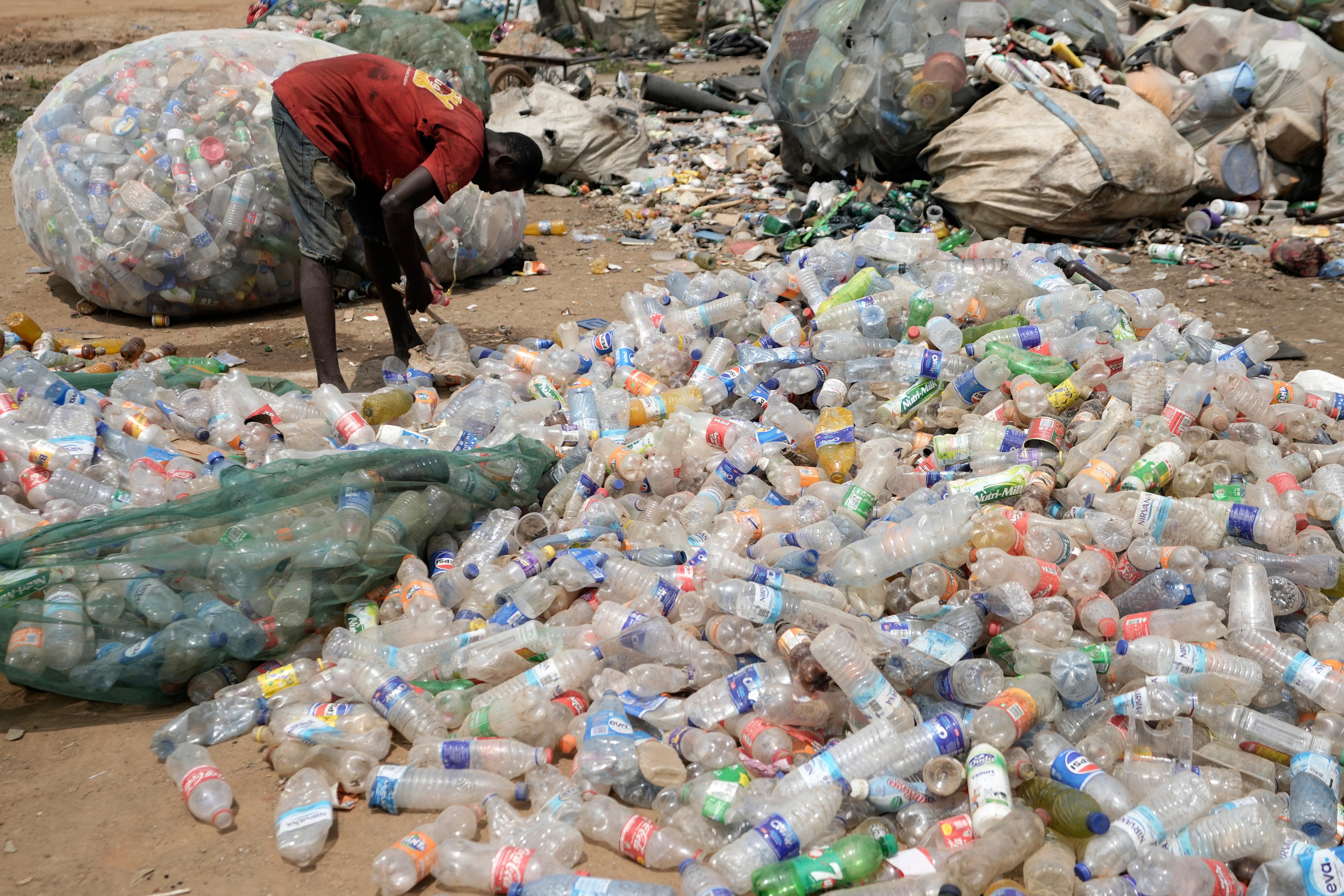 A scavenger sorts out plastic waste at a dumpsite on the outskirts of Lagos, Nigeria, Monday, Aug 11, 2025. (AP Photo/Sunday Alamba)
