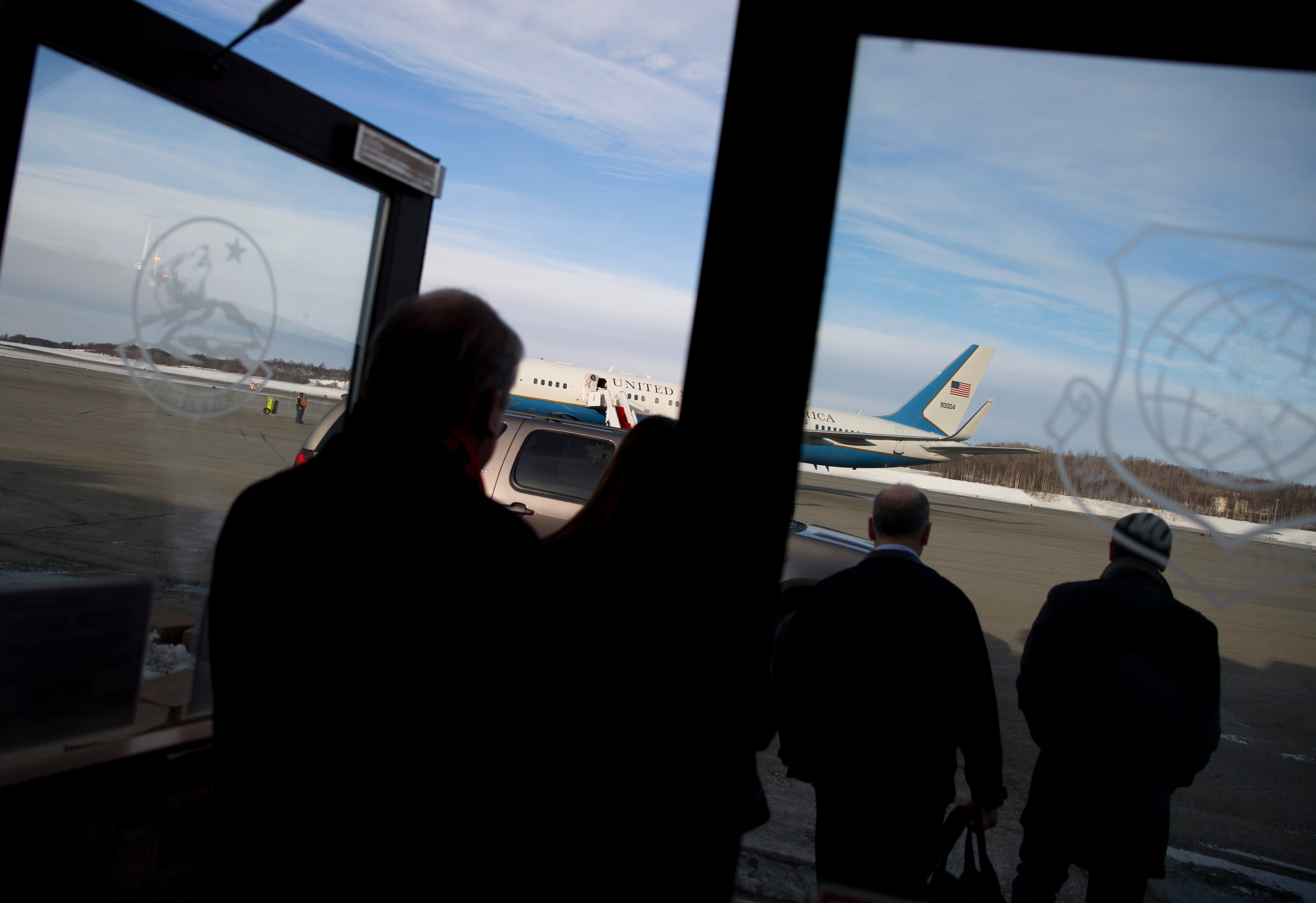 Staff members for former US secretary of state John Kerry walk to his plane after a refueling stop at Elmendorf Air Force Base in 2014