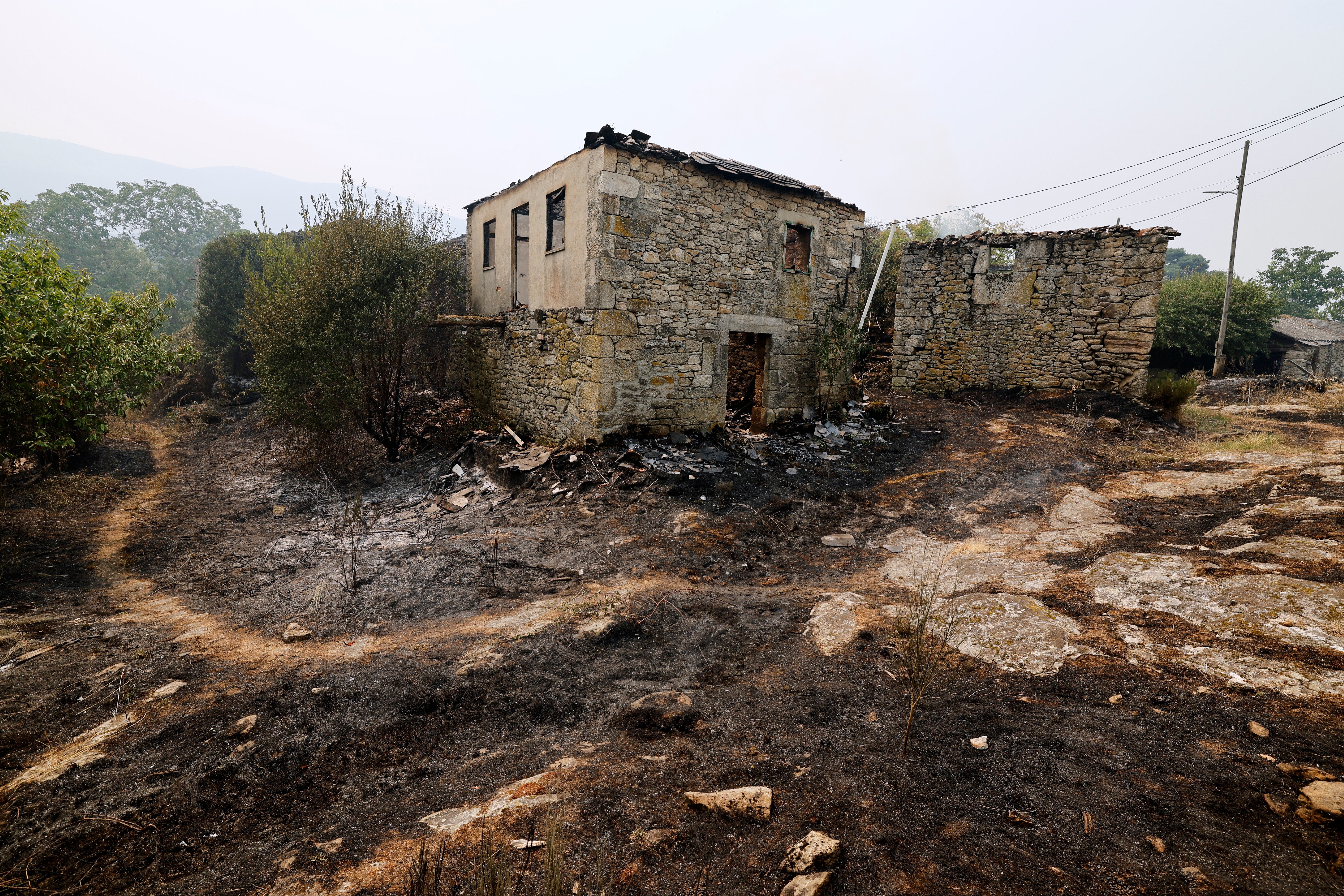 A burned house is pictured during the forest fire in Pareisas, northwestern Spain