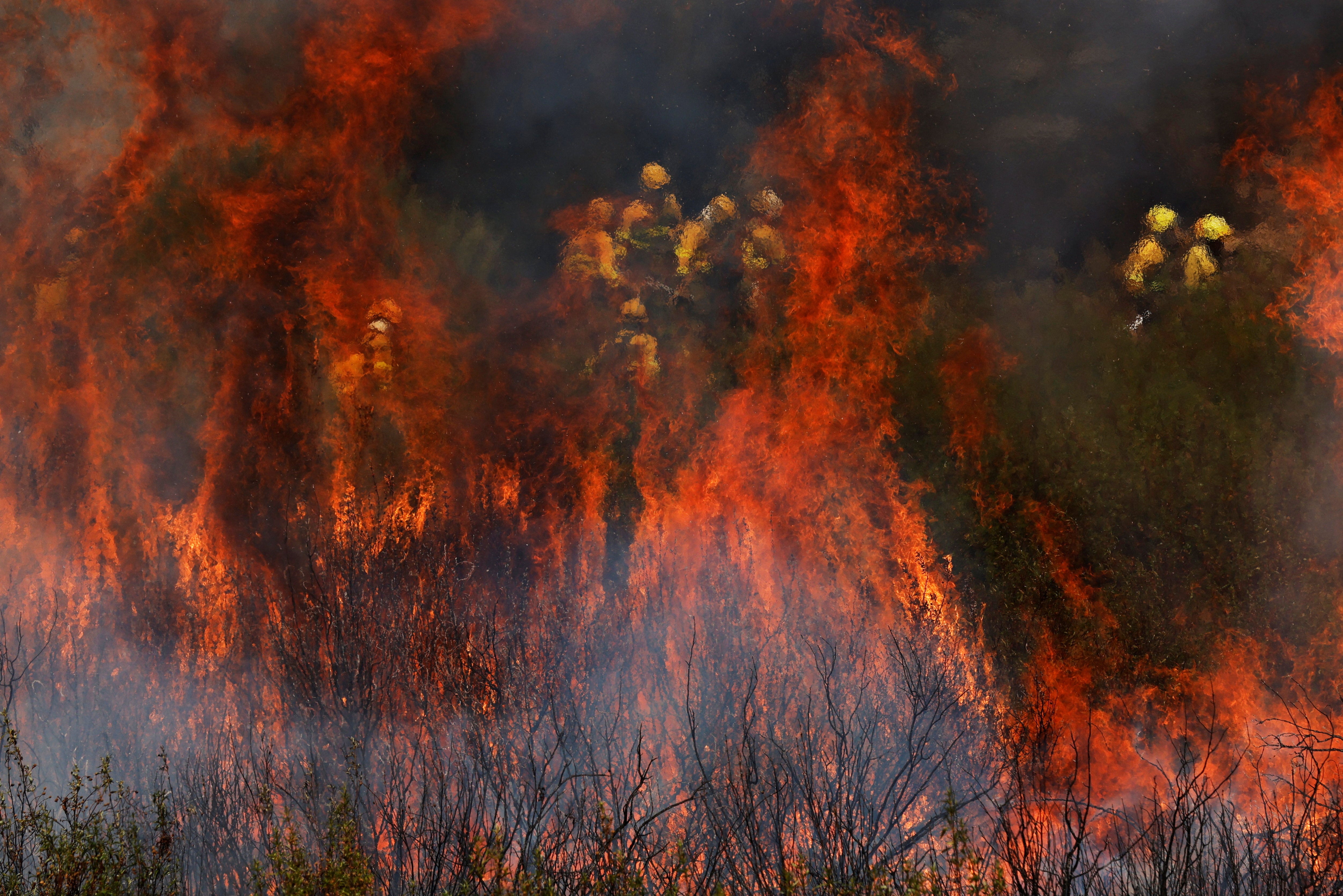 Firefighters work to extinguish a wildfire in the outskirts of Abejera de Tabara, Zamora, Spain, August 13, 2025. REUTERS/Susana Vera
