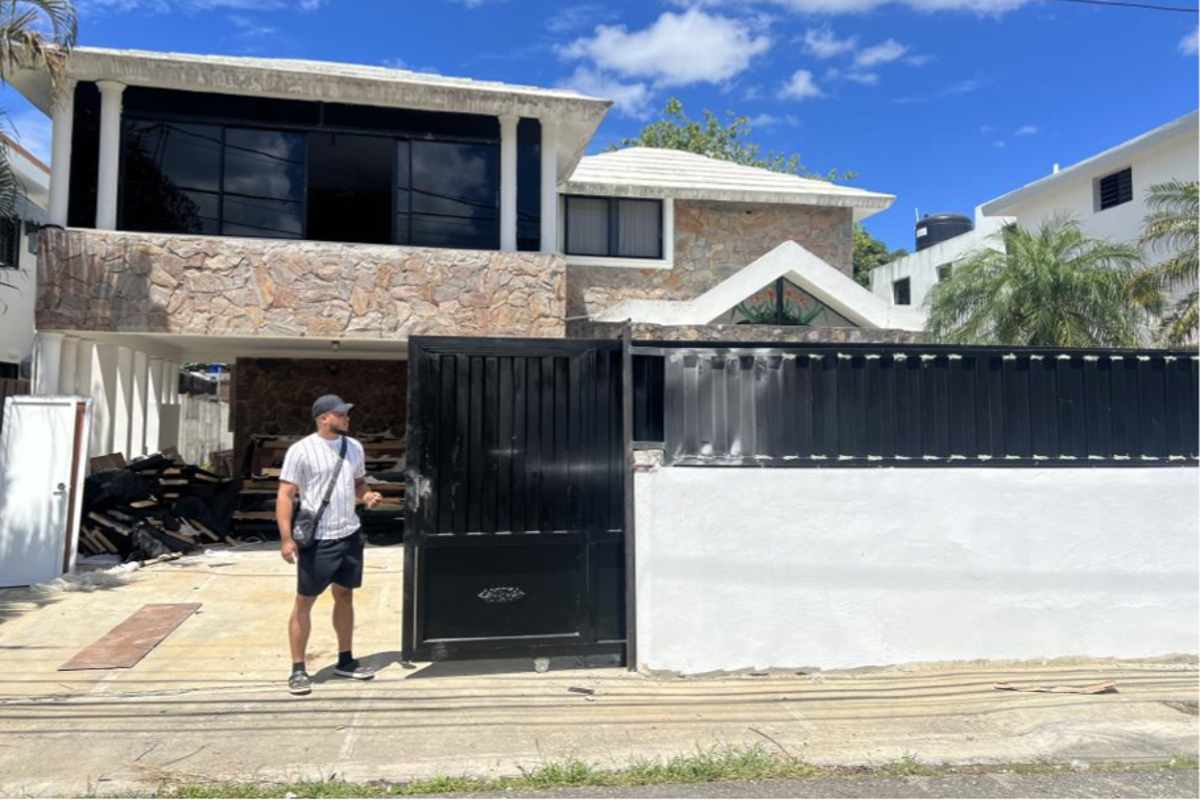 https://static.the-independent.com/2025/08/13/2/26/One-of-the-defendants-outside-of-a-call-center-which-were-typically-run-out-of-homes-in-the-Dominica.png?trim=77,0,0,0&width=1200&height=800&crop=1200:800