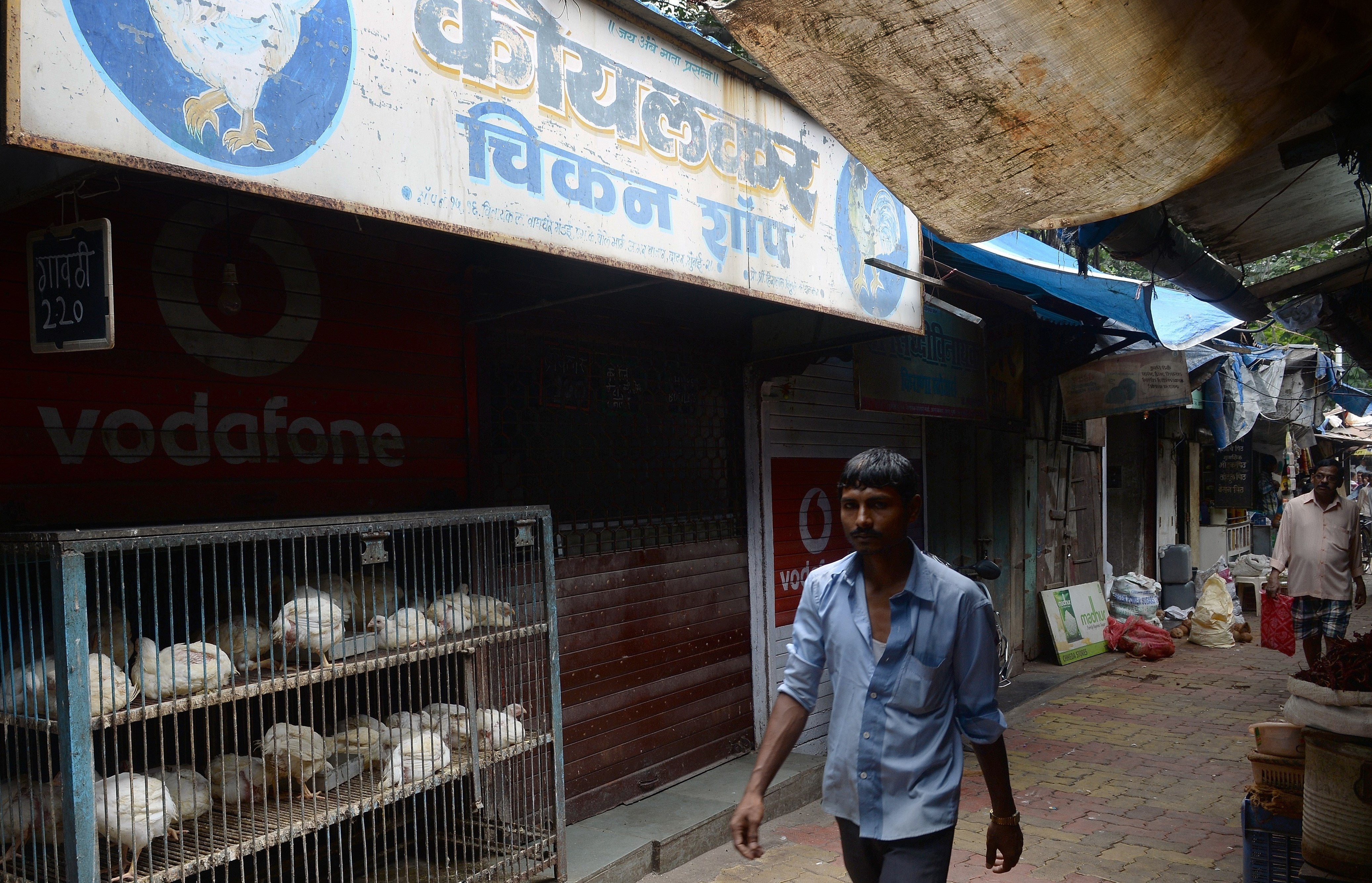 File: An Indian man walks past a closed chicken shop inside a local market on the first day of a four-day ban on the sale of meat in Mumbai on September 10, 2015
