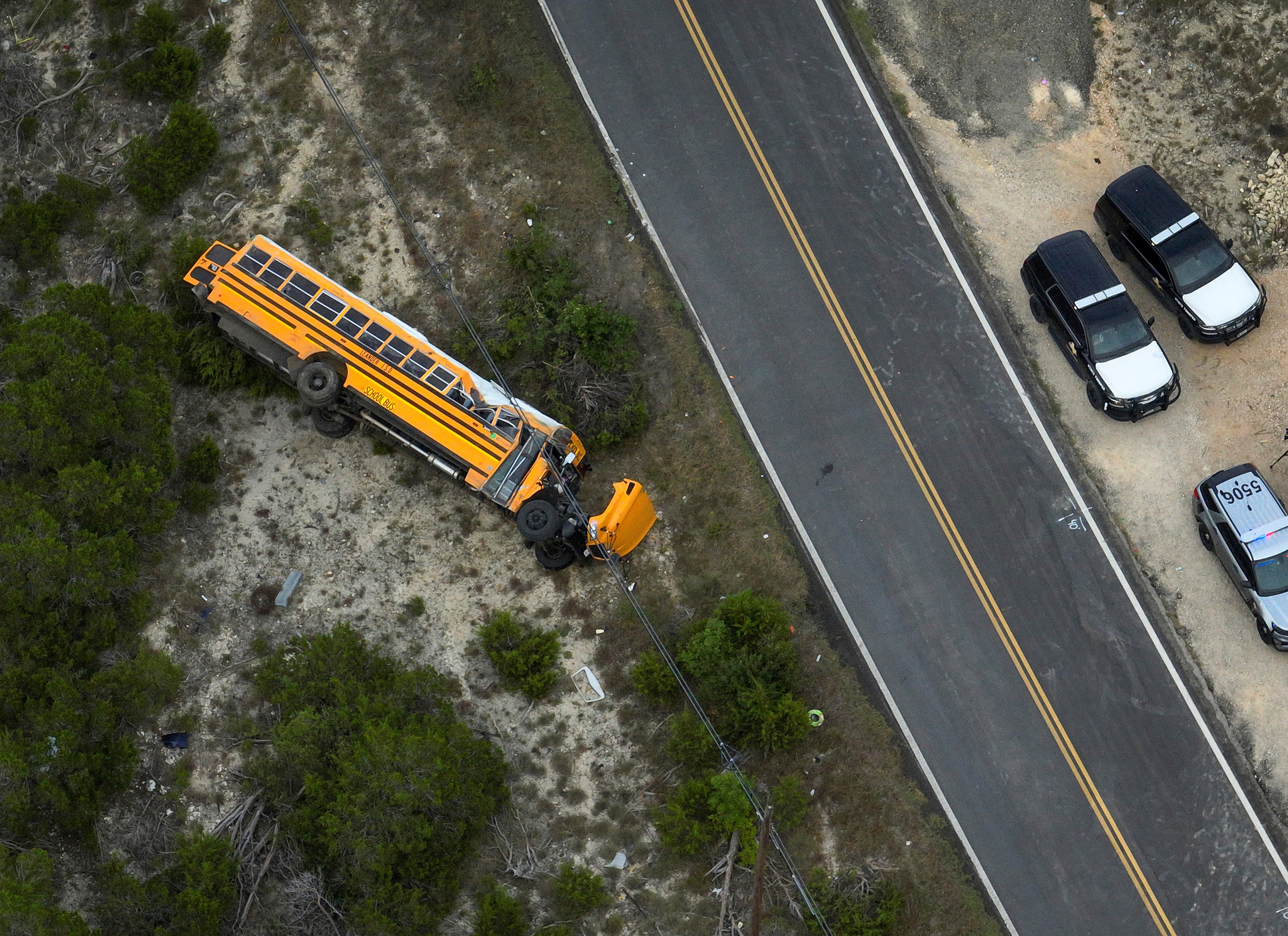 A Texas school bus carrying 43 people, mostly elementary school students, rolled onto its side after the vehicle veered off the road on the first day of class