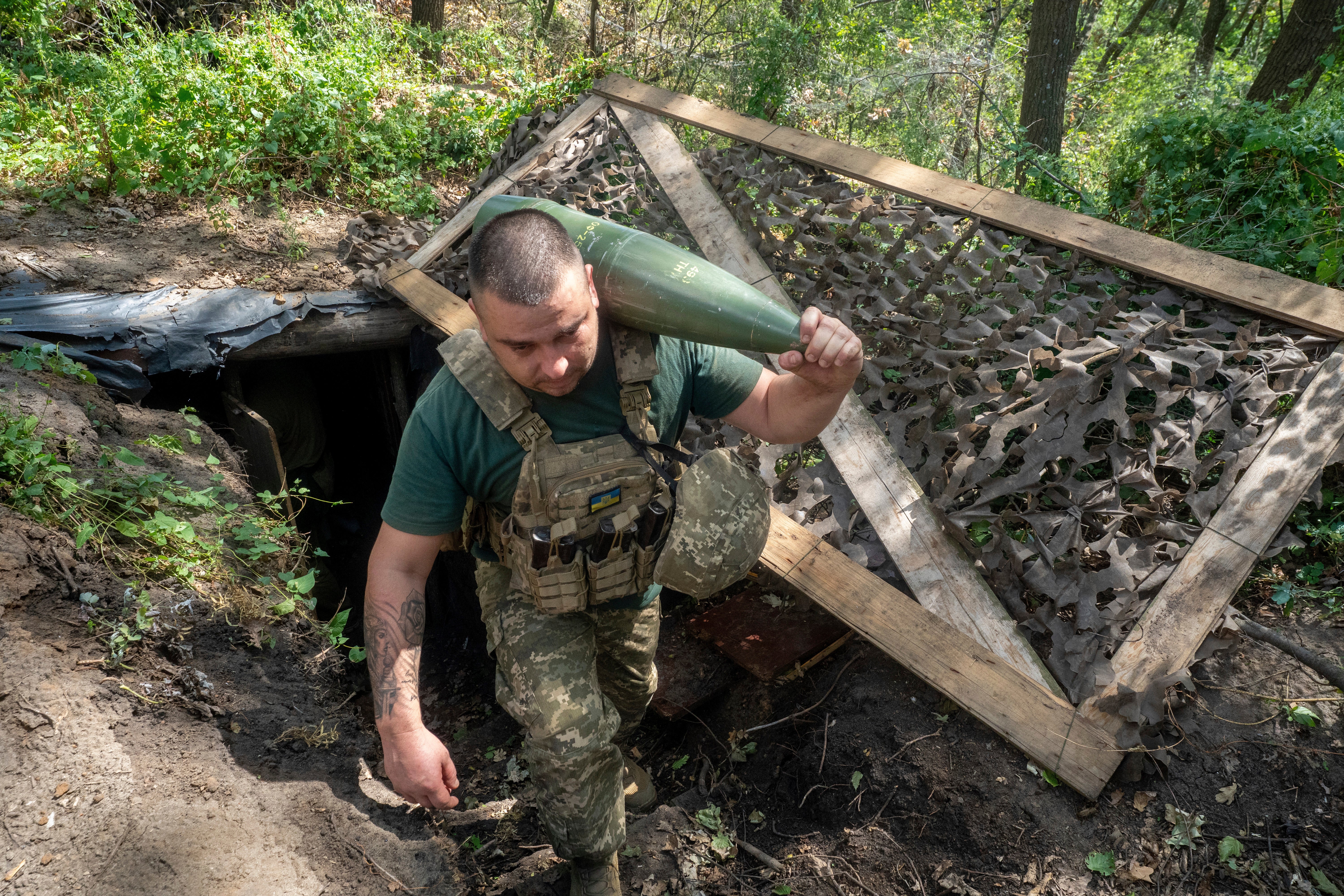 A Ukrainian soldier prepares to fire a howitzer towards Russian positions on the front line near Kharkiv, Ukraine, on Wednesday