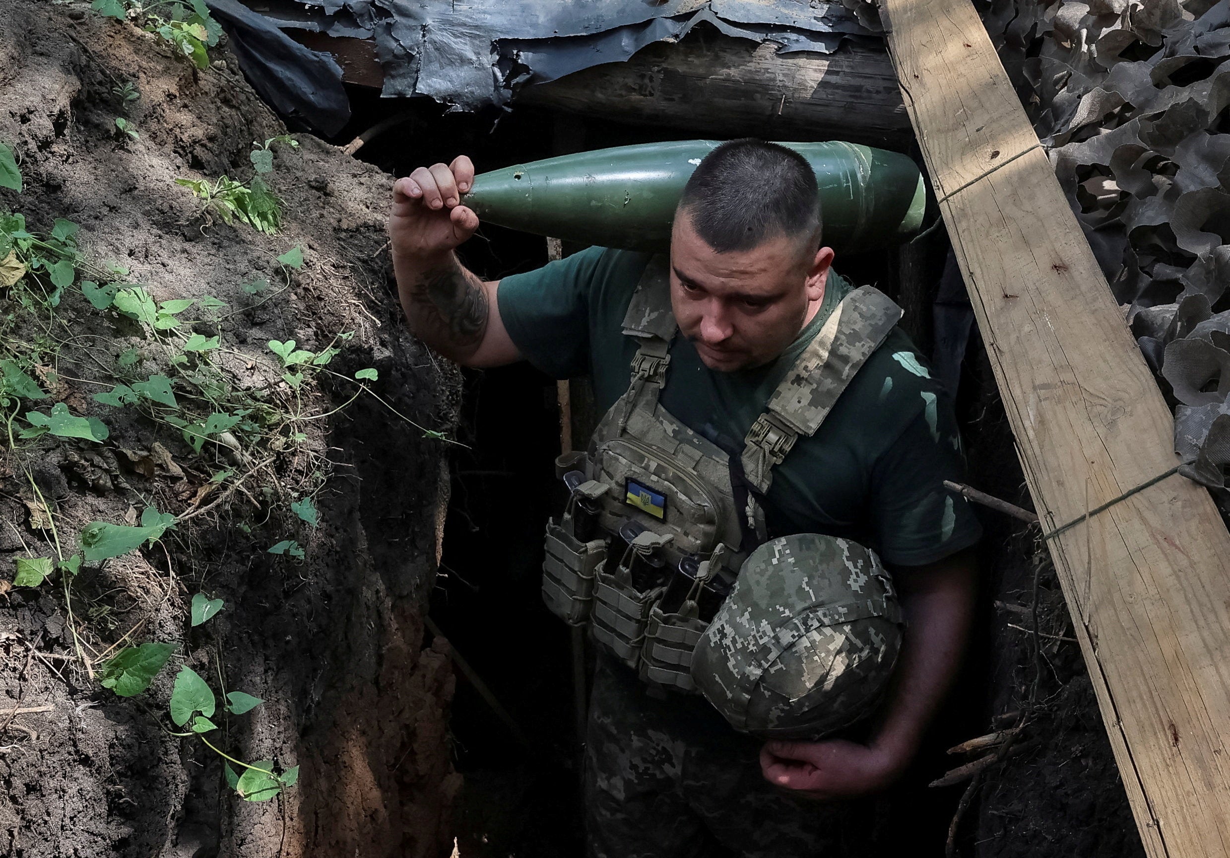 In a separate attack, a Ukrainian serviceman carries a shell for a 2S1 Gvozdika self-propelled howitzer before firing towards Russian troops on the front line in the Donetsk region on Wednesday
