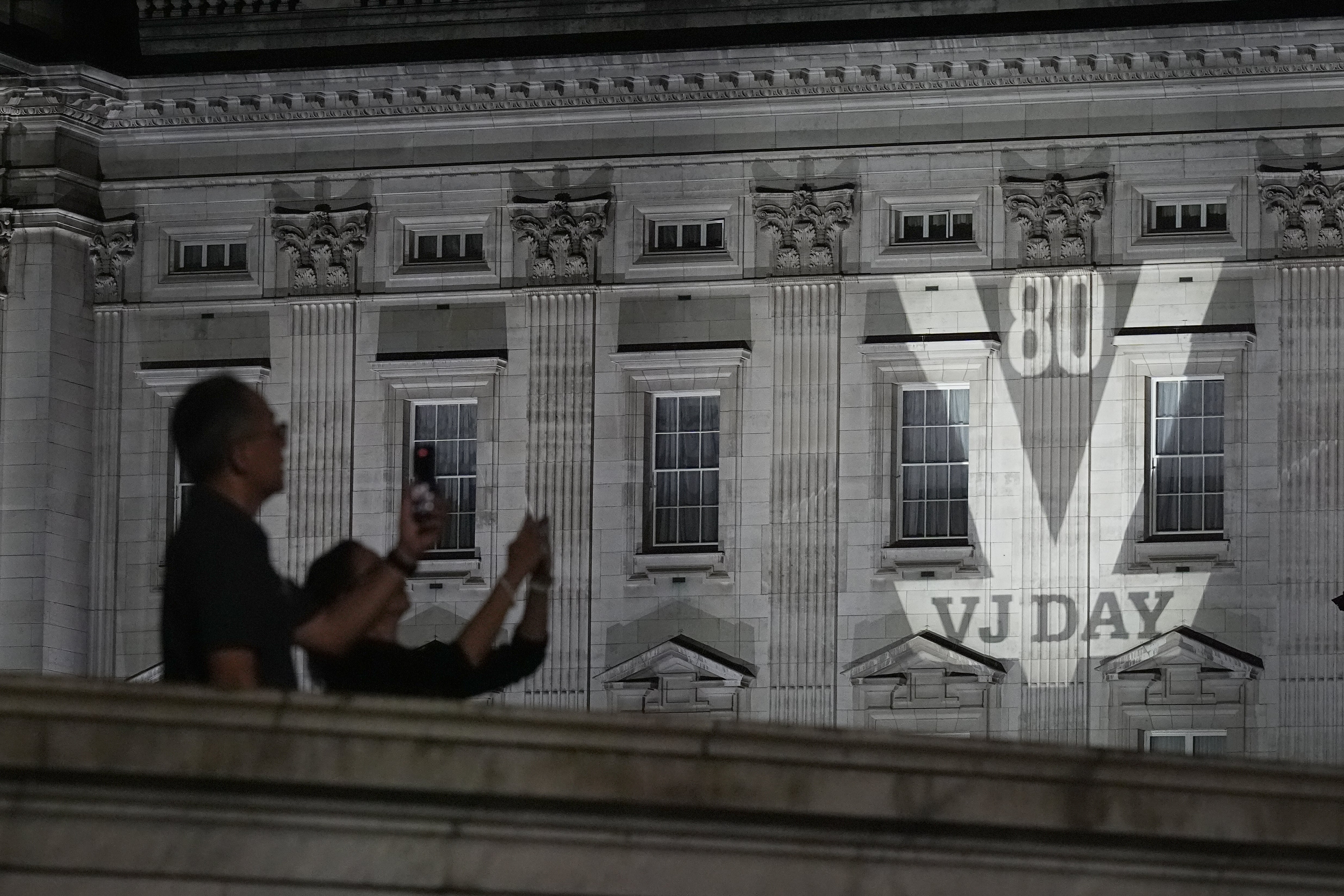 A VJ Day sign projected onto Buckingham Palace