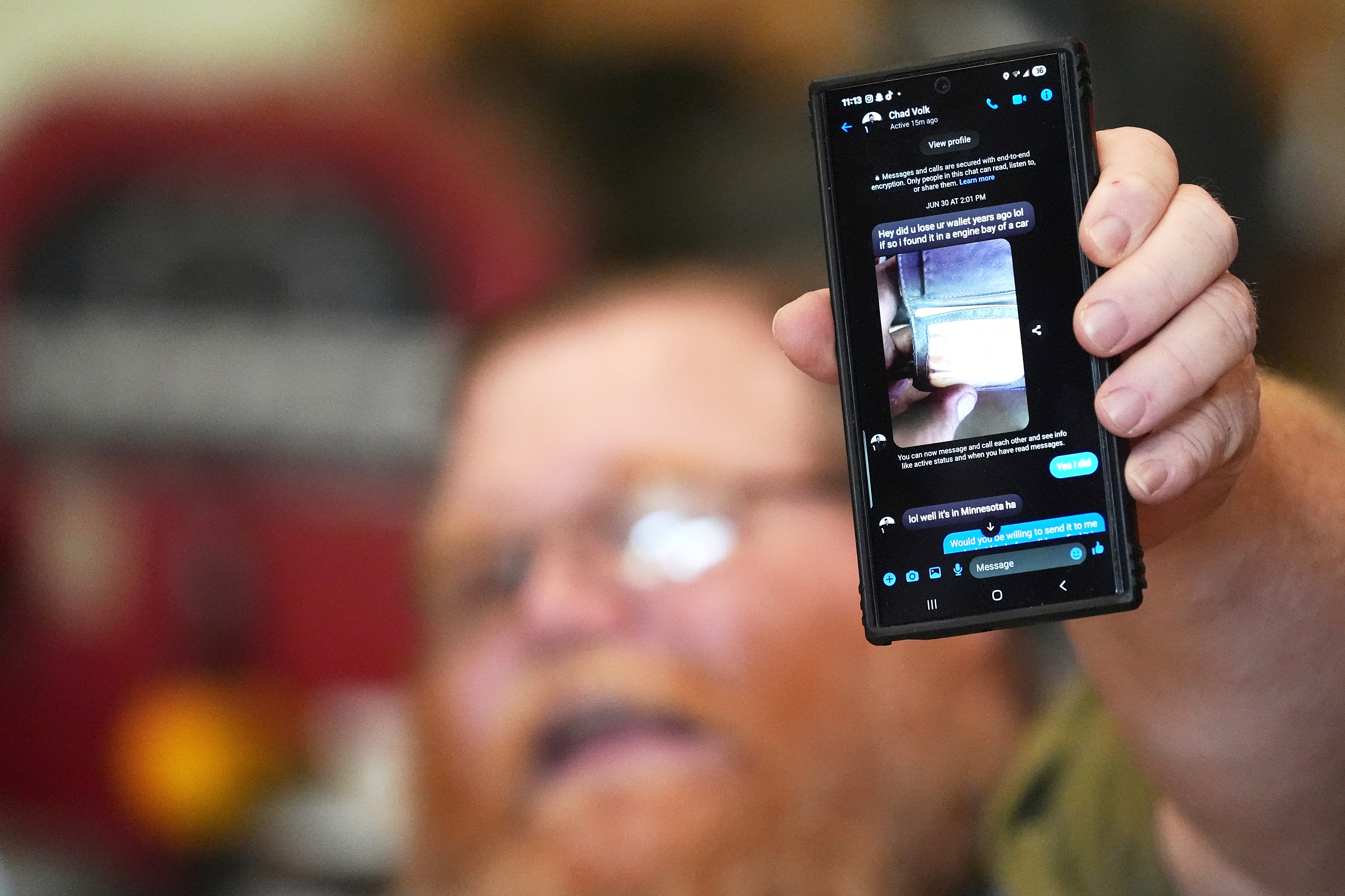 Richard Guilford holds up a chat message he received from Chad Volk during an interview Thursday, Aug. 14, 2025, in Petersburg, Mich. (AP Photo/Ryan Sun)