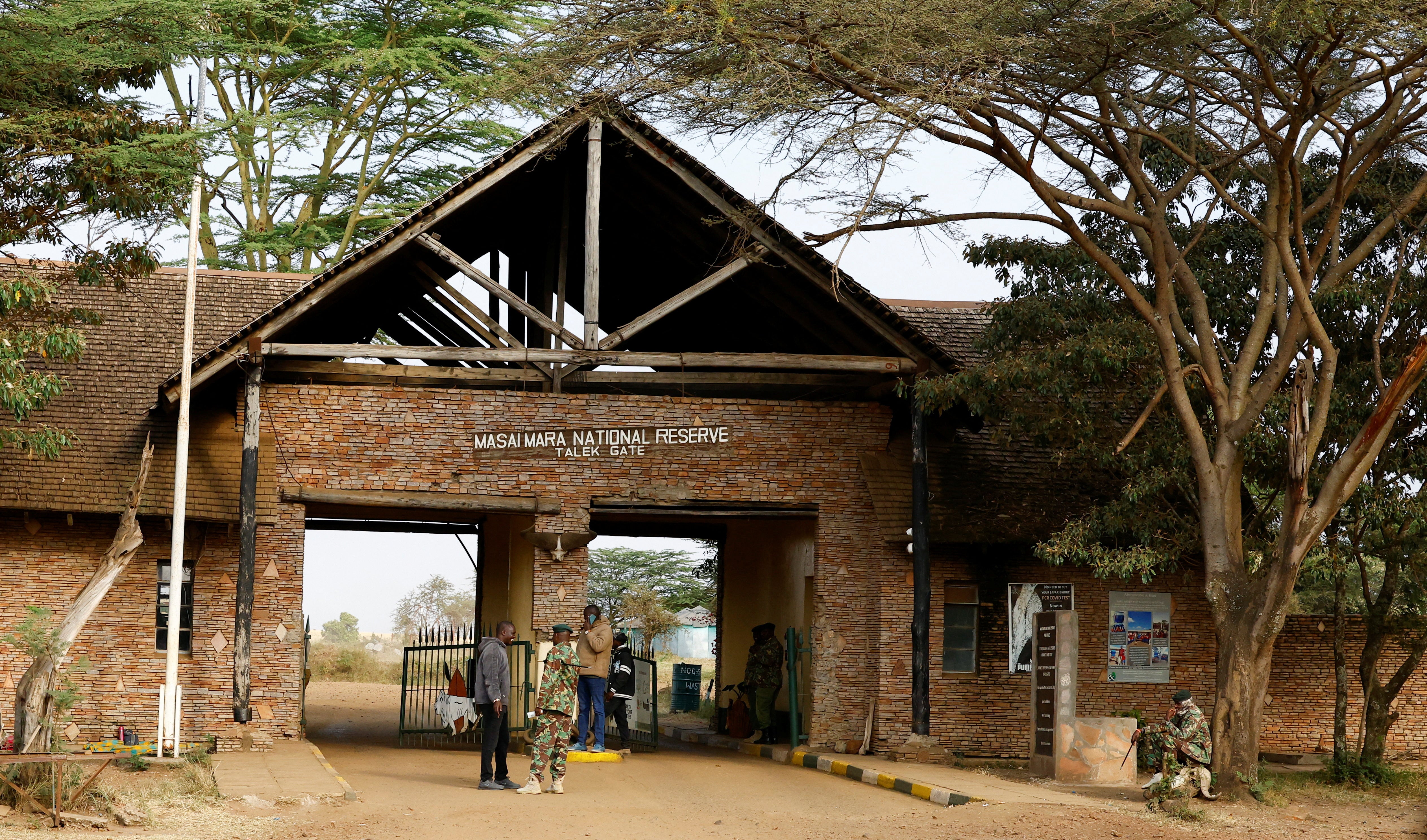 Rangers and visitors stand at the Talek gate in the Maasai Mara game reserve
