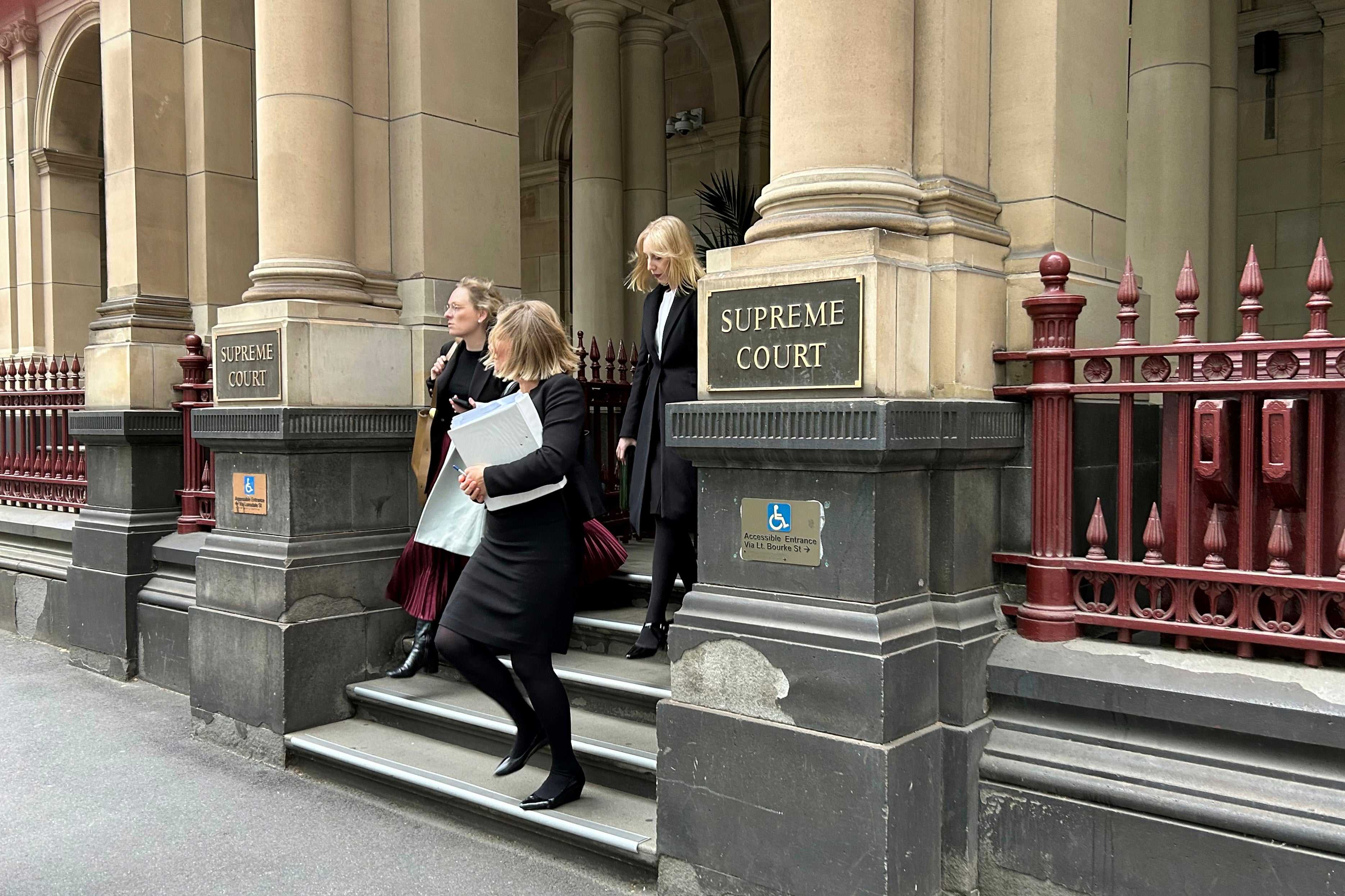 People leave the Supreme Court of Victoria in Melbourne, on Friday, Aug. 15, 2025. (AP Photo/Rod McGuirk)