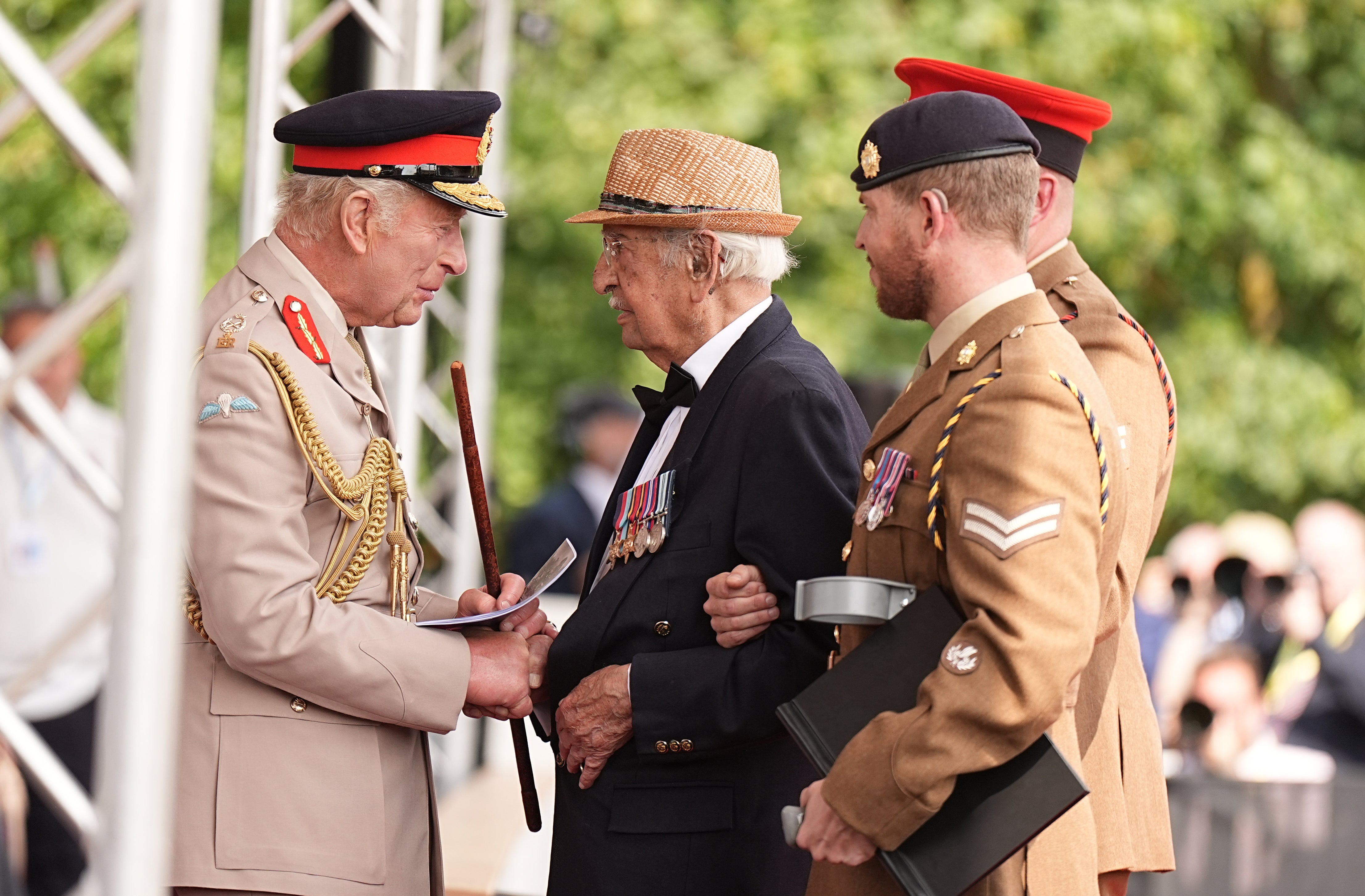 King Charles shakes hands with veteran Abbas (centre)