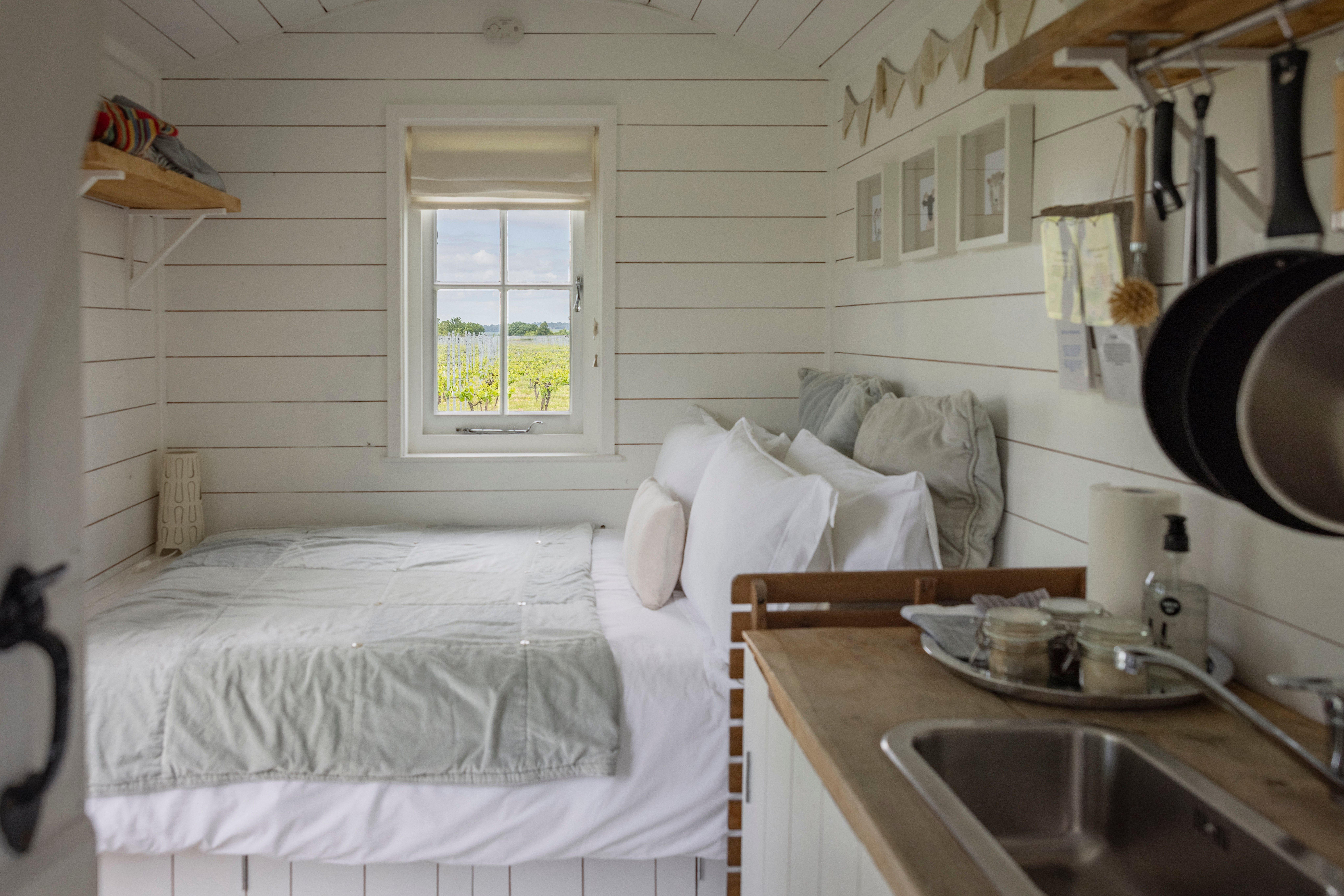 The cosy shepherd's hut accommodations at Oxney Organic Estate offer somewhere stylish to bed down with views of the vines all around