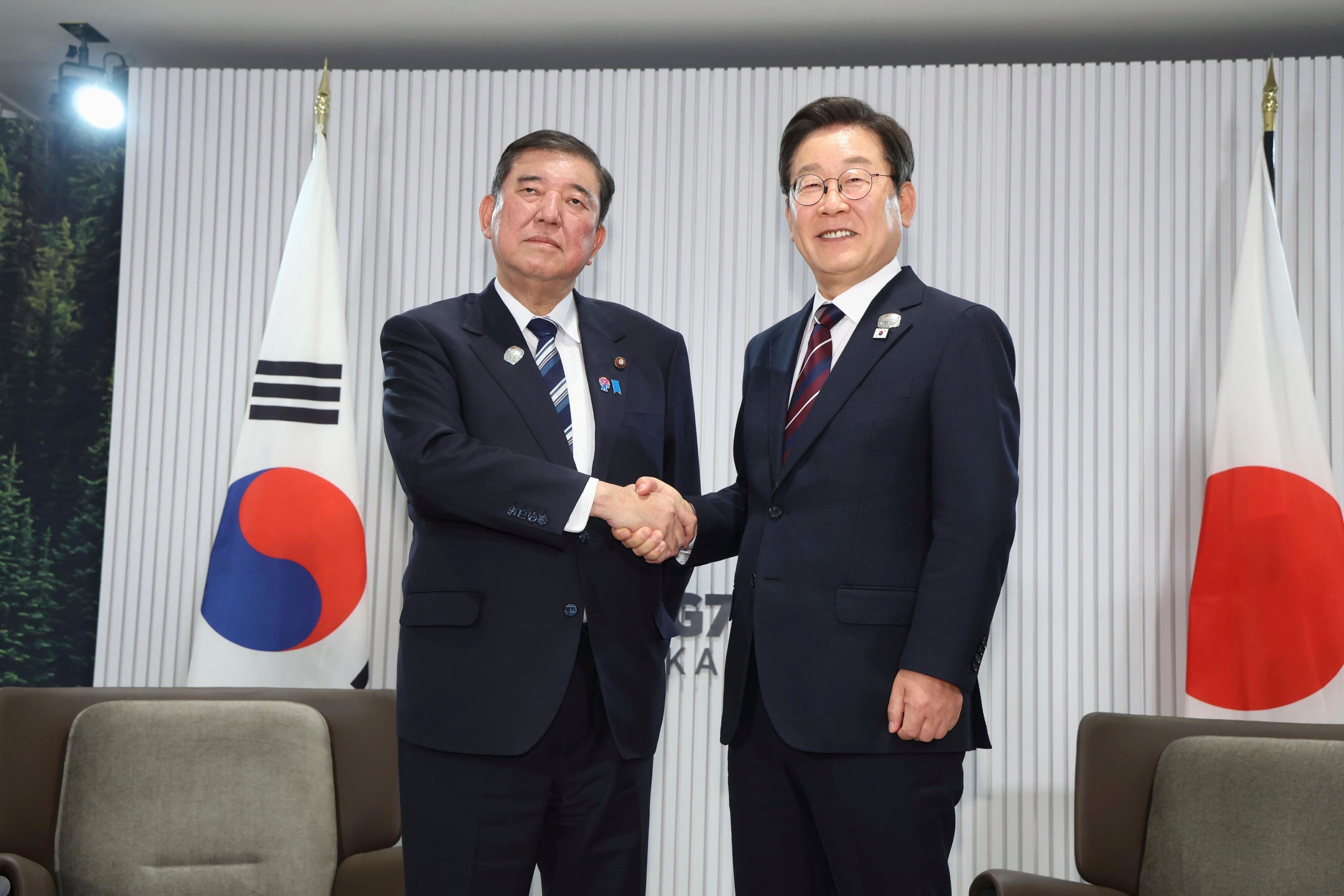 Japanese prime minister Shigeru Ishiba (left), and South Korean president Lee Jae Myung shake hands ahead of a bilateral meeting in Kananaskis, Alberta