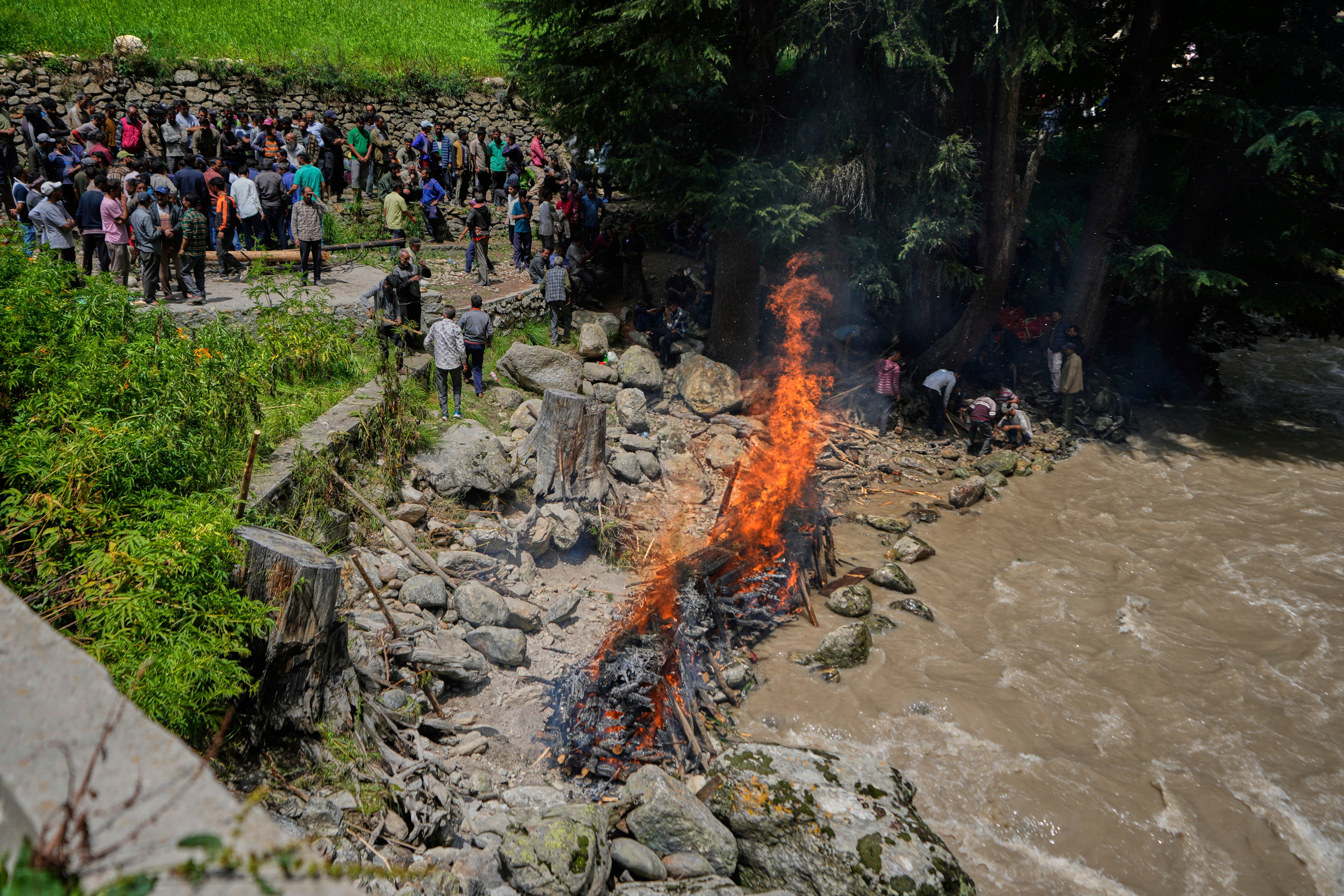 Villagers perform mass cremation of eight people died in a flash flood on the banks of the river Chenab in Chositi village, Kishtwar district, Indian-controlled Kashmir, Friday, Aug. 15, 2025. (AP Photo/Channi Anand)