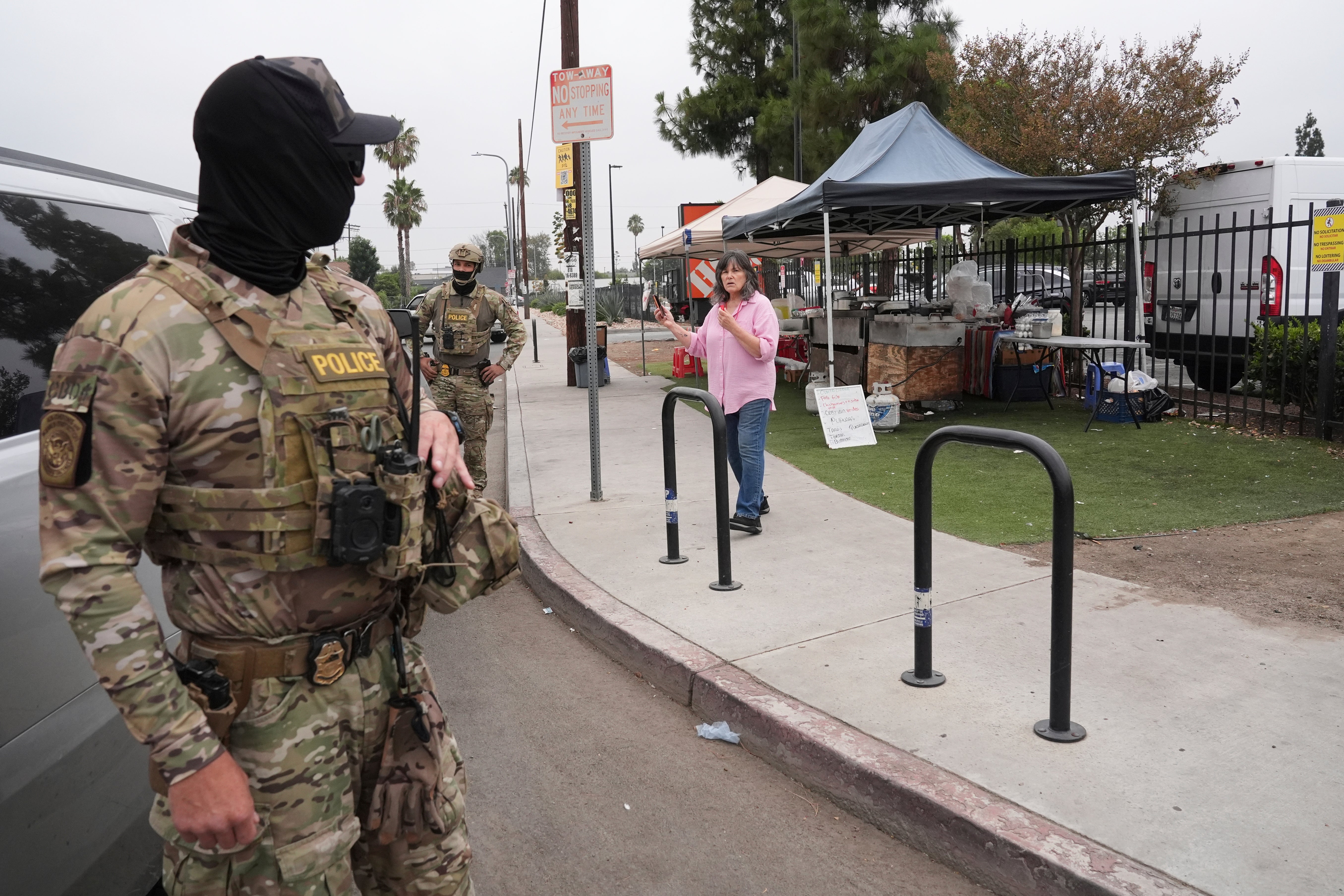 People film federal agents during an operation outside a Home Depot on Friday in Los Angeles. Some Democrats have called on Trump to end the raids