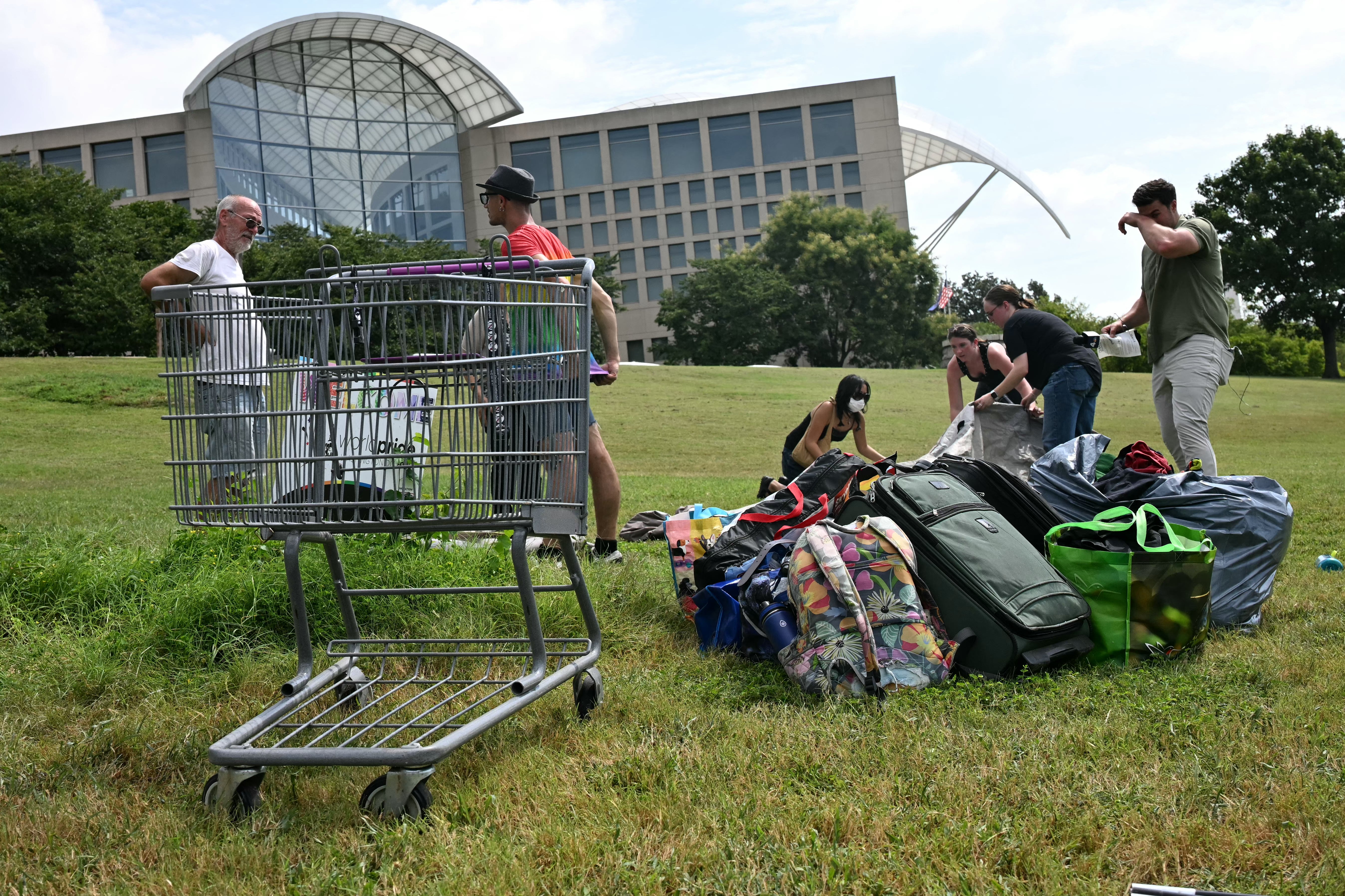 Volunteers help people take down their tents and collect their belongings as D.C. city workers conduct a sweep of a homeless encampment in the Foggy Bottom neighborhood