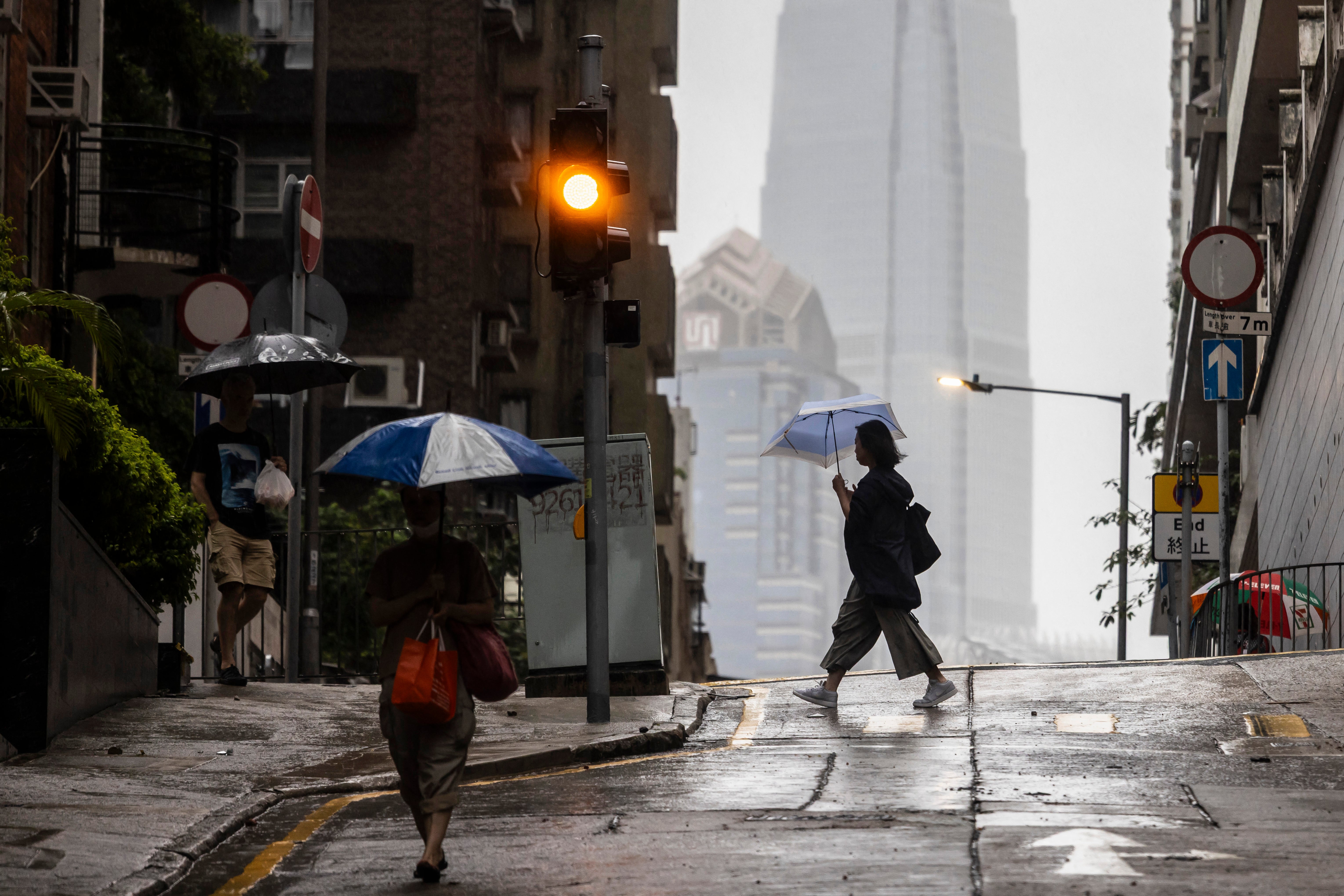 People use umbrellas to protect themselves from the rain in Hong Kong
