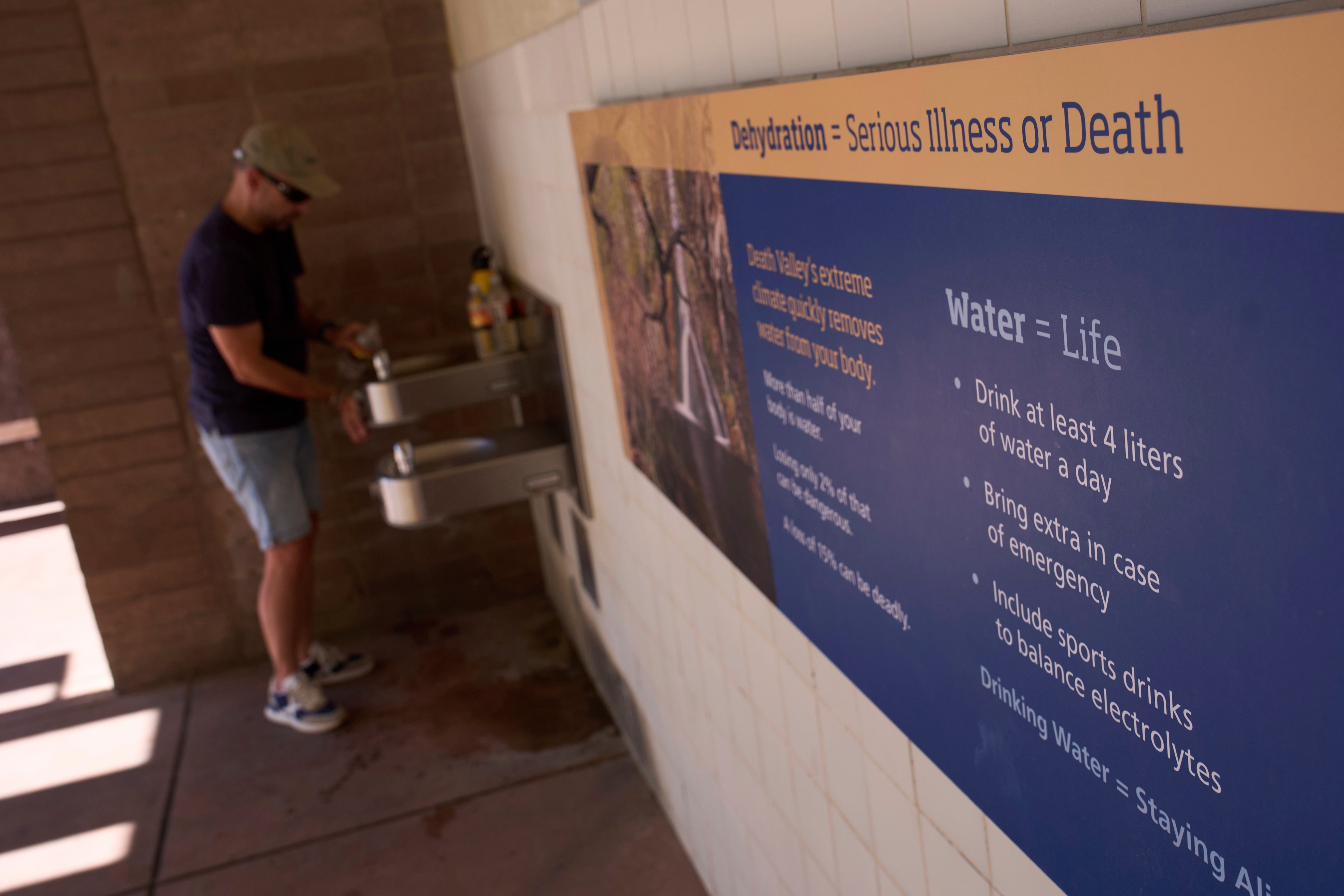 Pedro Luque, of Spain, fills up water bottles at the Furnace Creek Visitor Center in Death Valley National Park